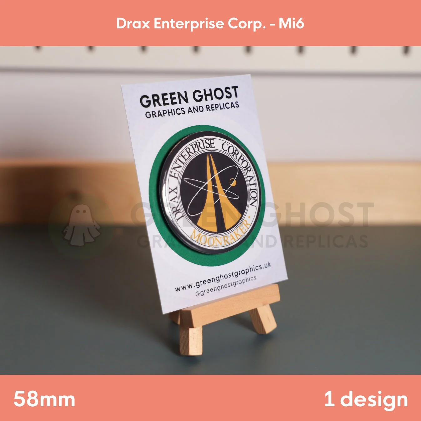 A round badge with a stylised gold rocket and orbit motif surrounded by “DRAX ENTERPRISE CORPORATION MOONRAKER” text attached to a branded card.