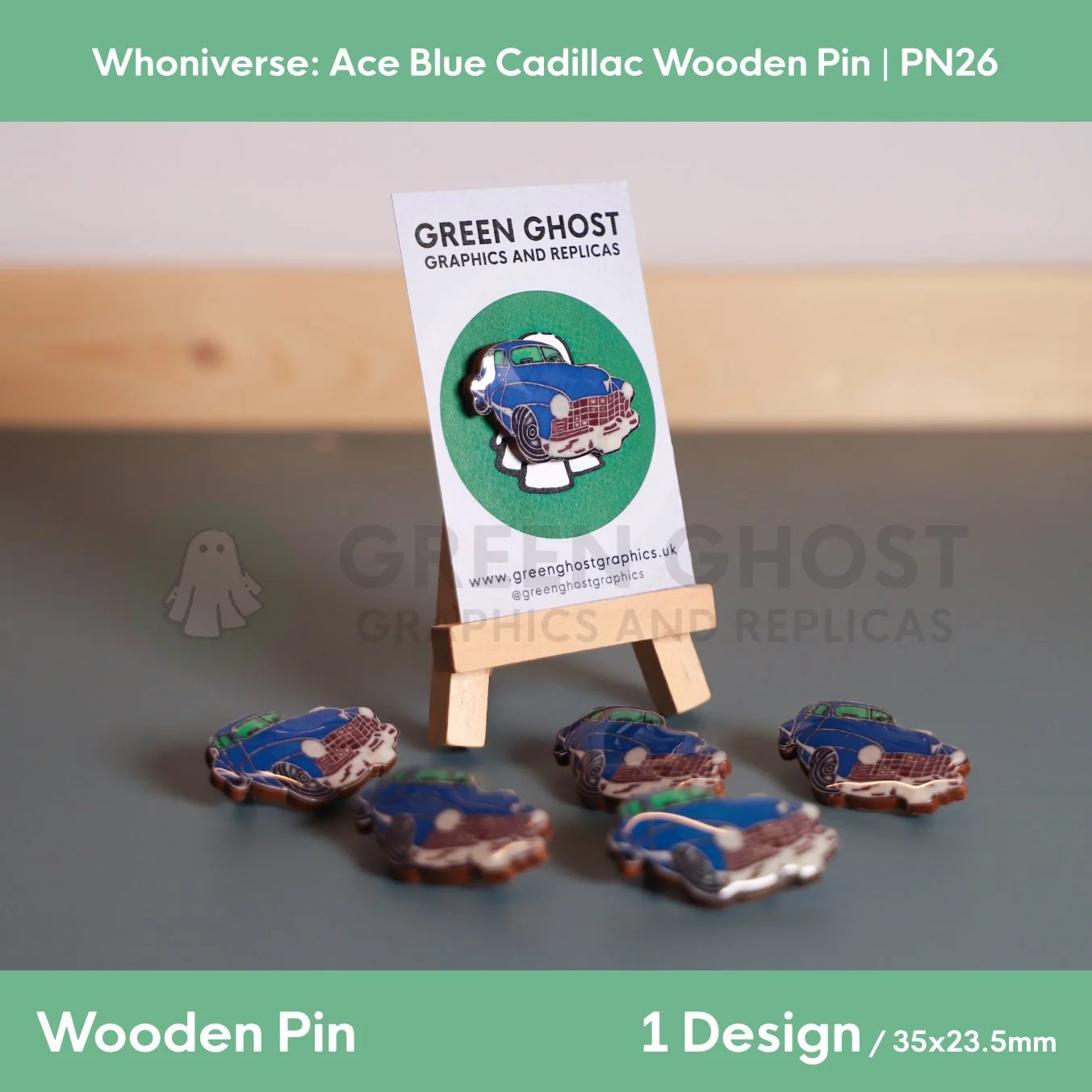 A blue Cadillac wooden pin attached to a branded backing card on a wooden easel, with several identical pins arranged neatly in front.
