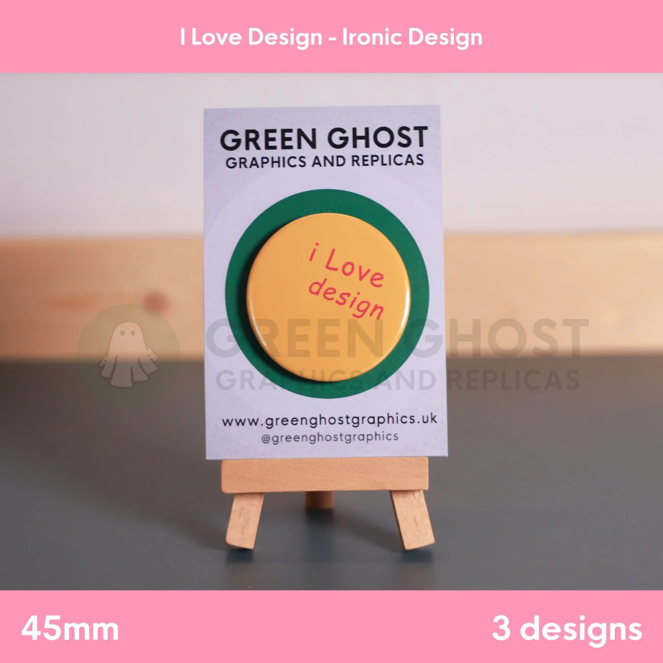 A round orange badge with red “i Love design” text mounted on a branded backing card on a wooden easel.