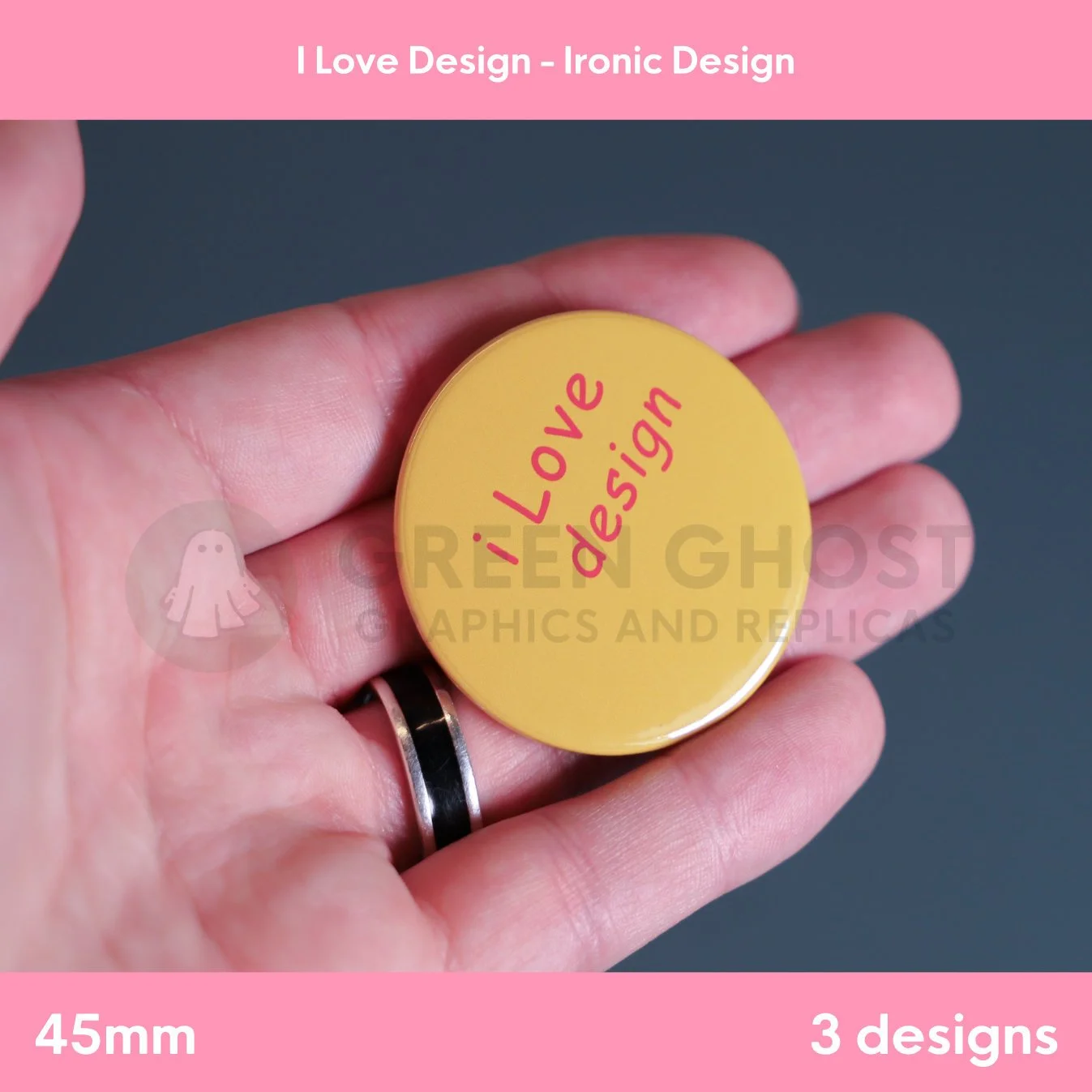 A round orange badge with red “I Love design” text held between fingers against a dark background.