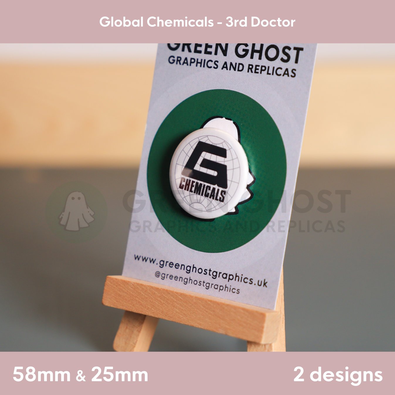 A round badge with a black “G CHEMICALS” logo and faint globe design displayed on a branded backing card on a wooden easel.