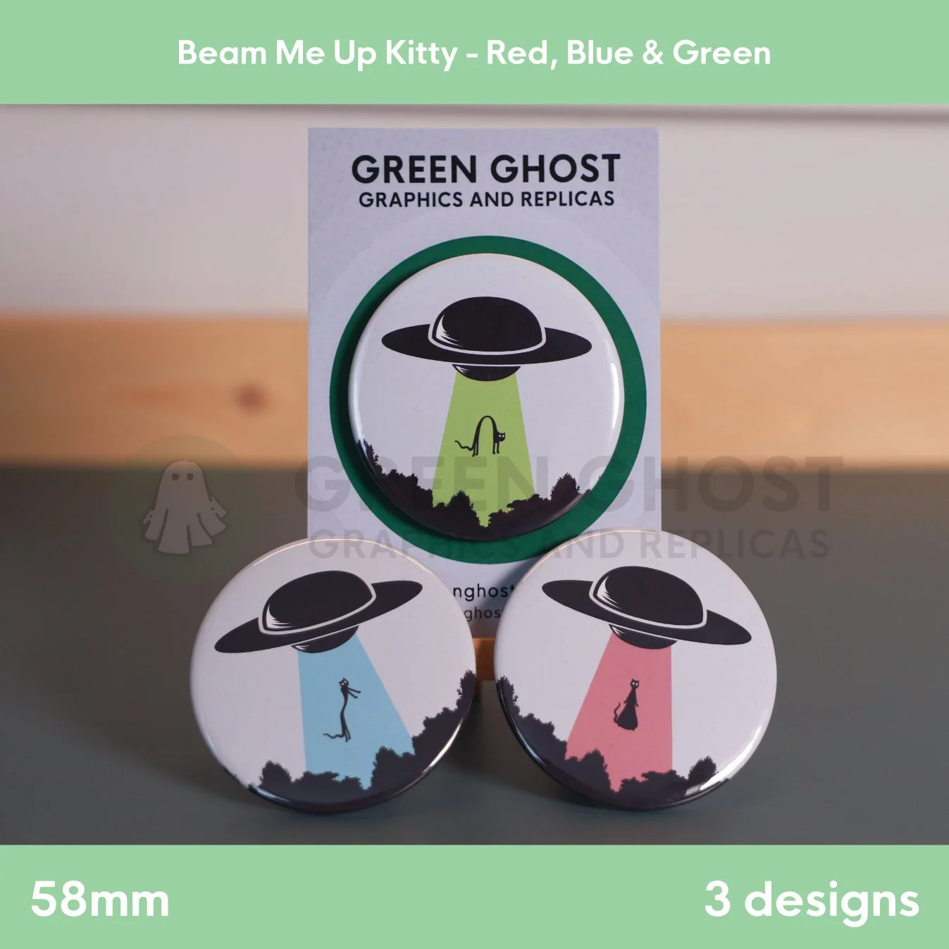 A round badge with a coloured UFO beam on a branded backing card on a wooden easel with two badges in front.