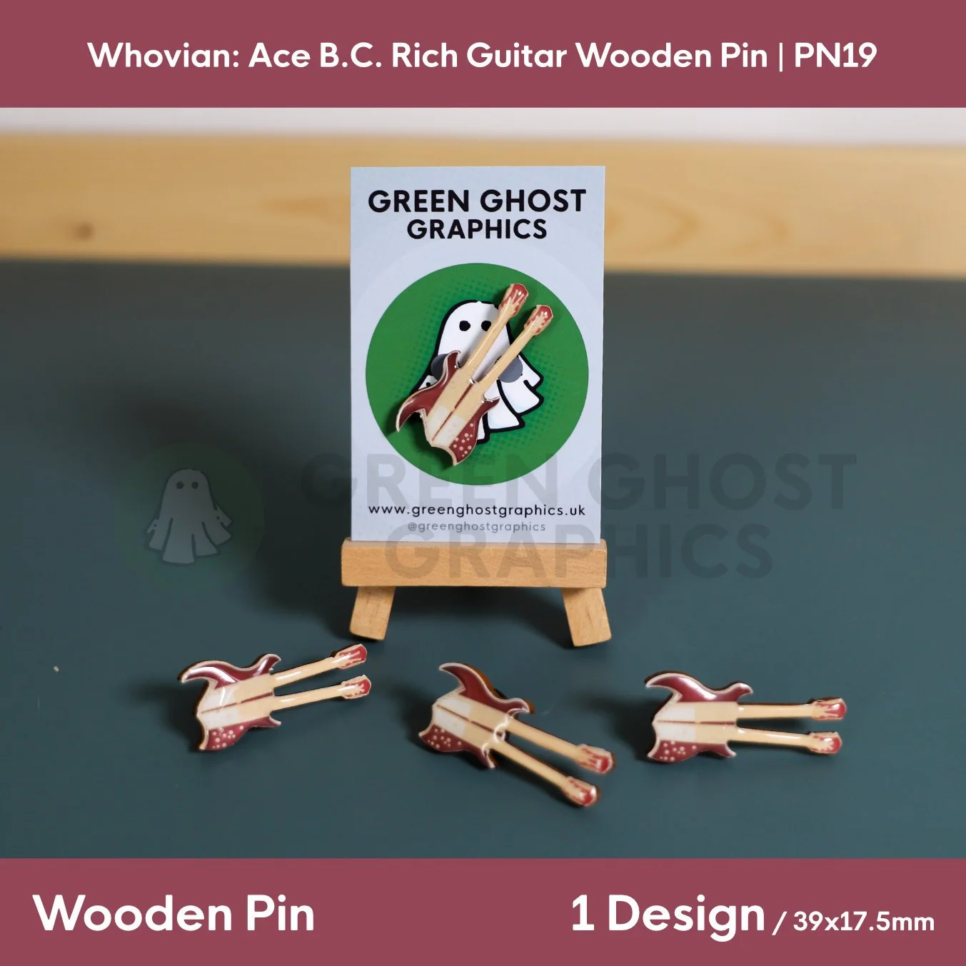 A brown and cream double‑neck guitar‑shaped wooden pin displayed on a Green Ghost Graphics card with three matching guitar pins arranged in front.