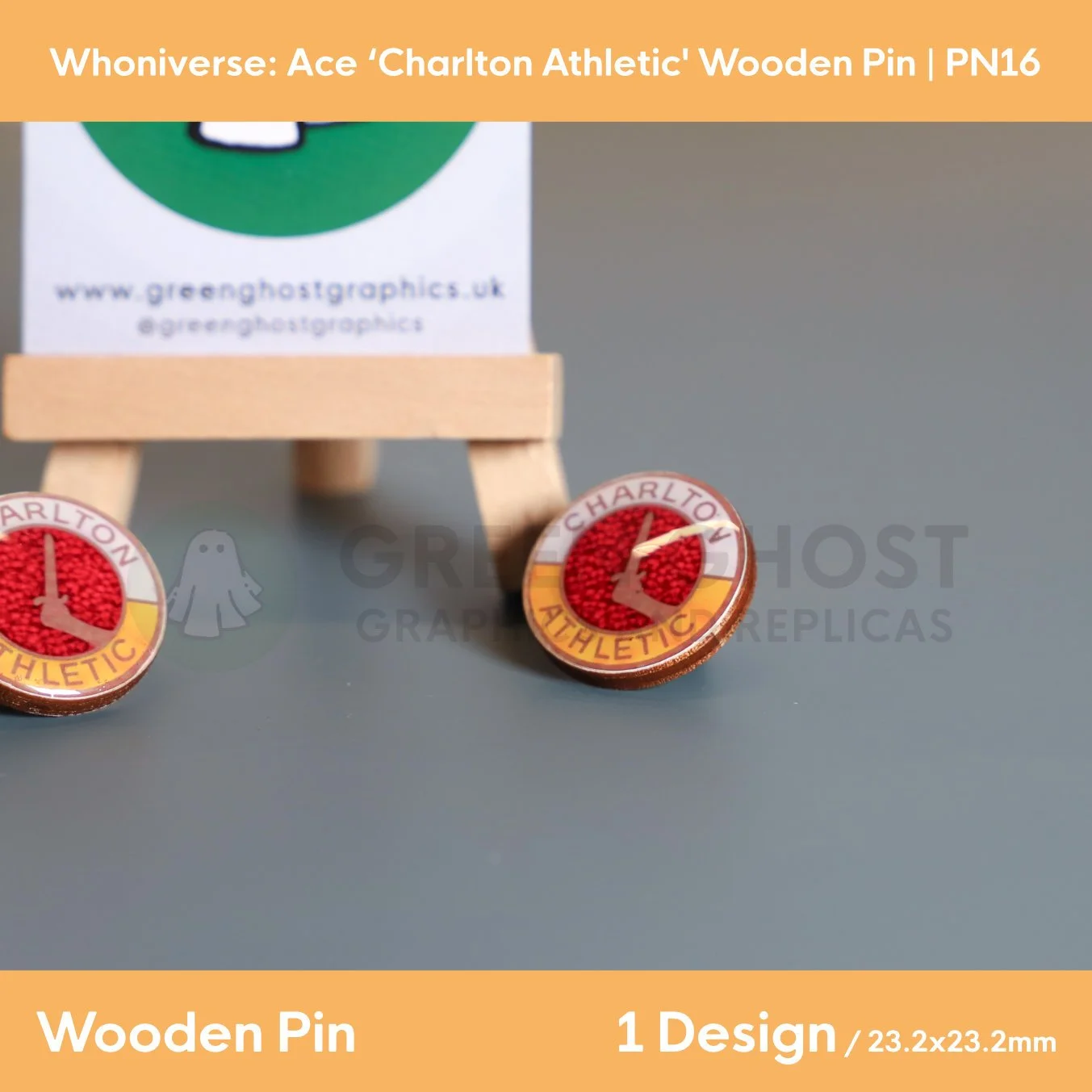 Two circular wooden “Charlton Athletic” pins on a grey surface, one resting against a wooden easel holding a branded backing card.