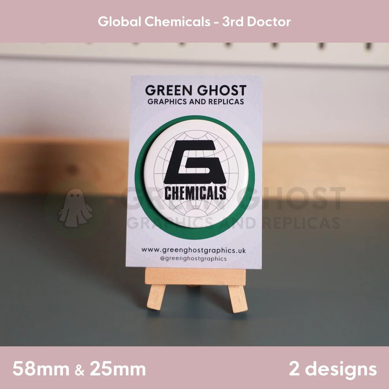 A round badge with a stylised “G CHEMICALS” design over a faint globe grid displayed on a branded card on a wooden easel.