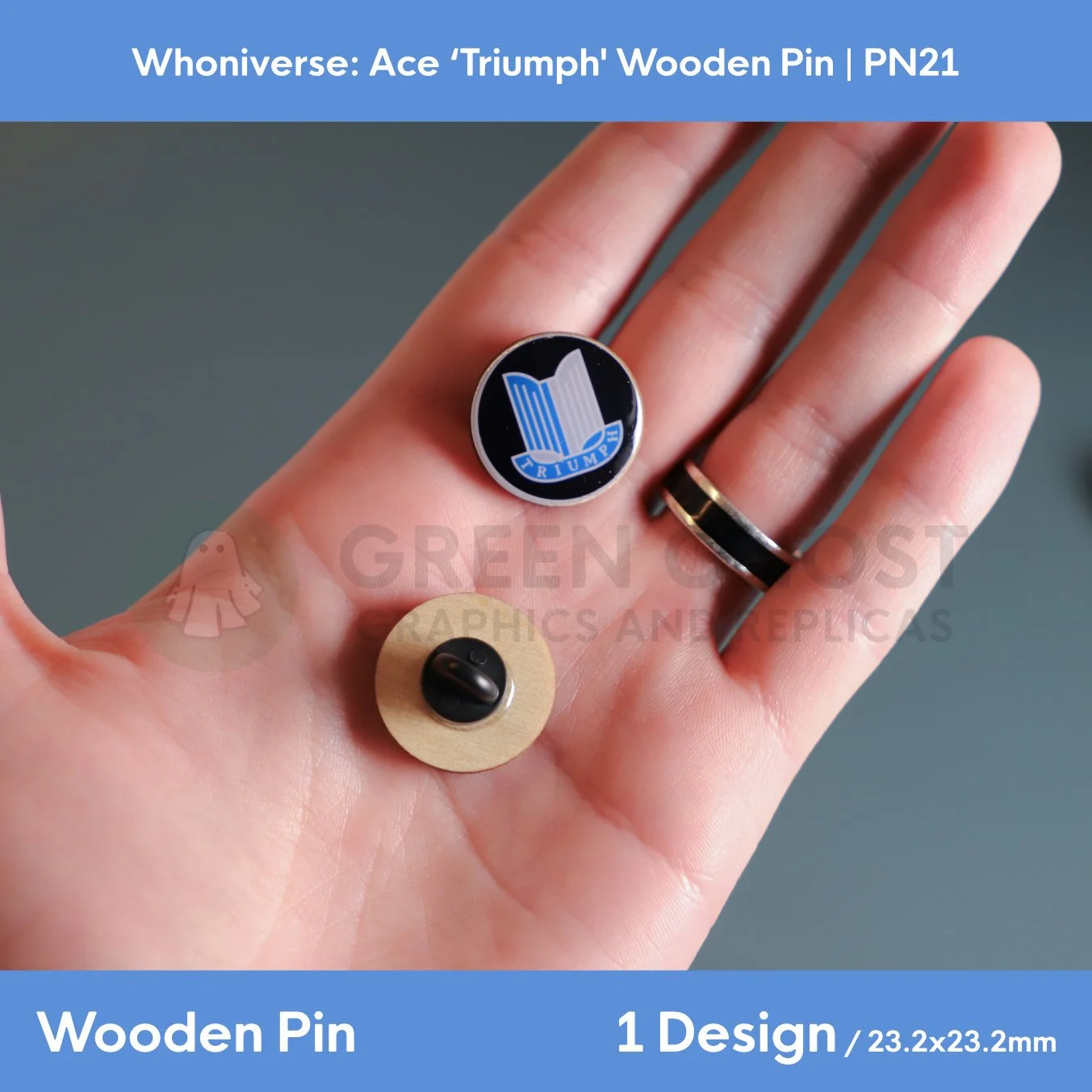 A close‑up of two circular wooden “TRIUMPH” pins held in a hand, showing the front emblem design and the back with a clasp attachment.