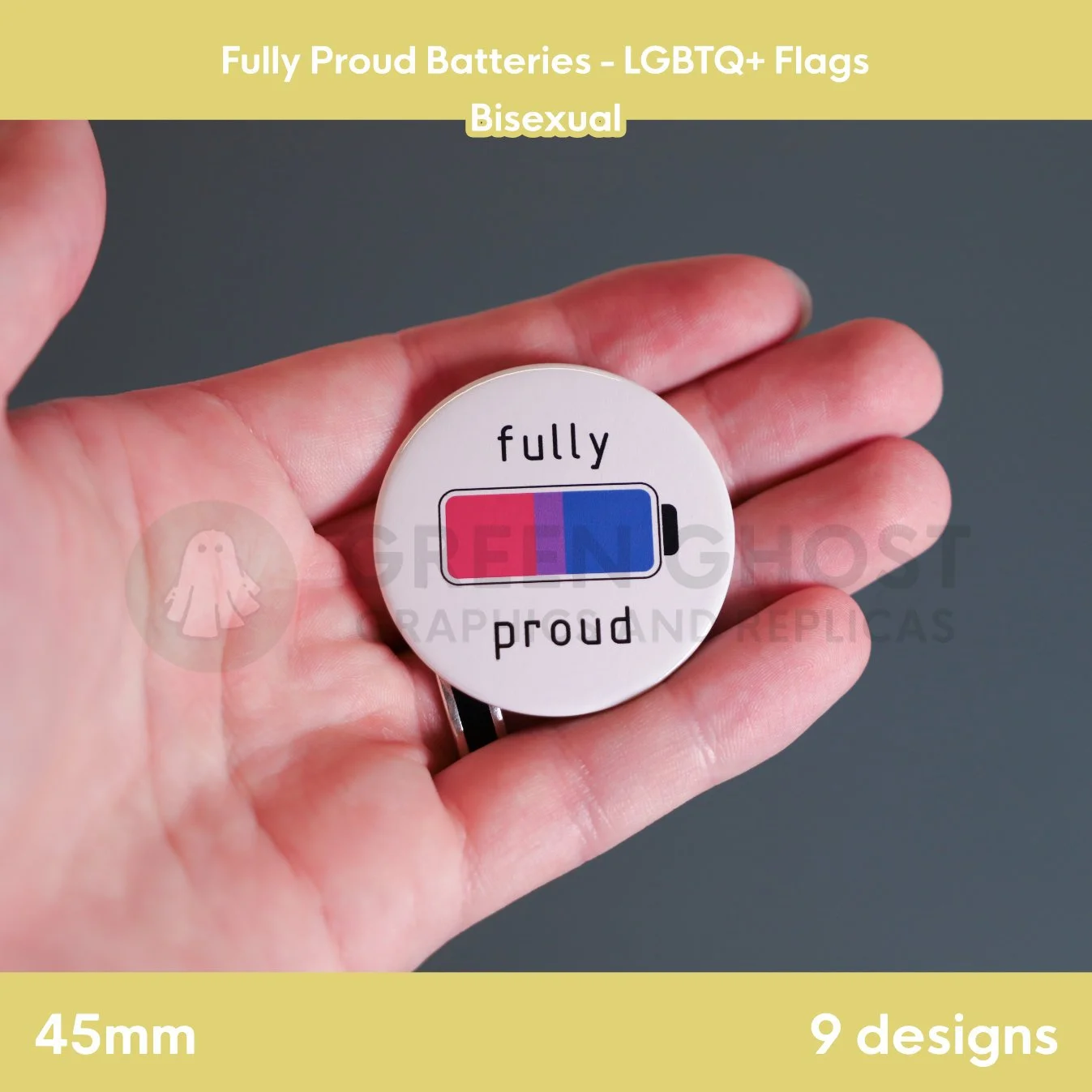 A round badge with a pink, purple, and blue battery design held in a hand against a grey background.