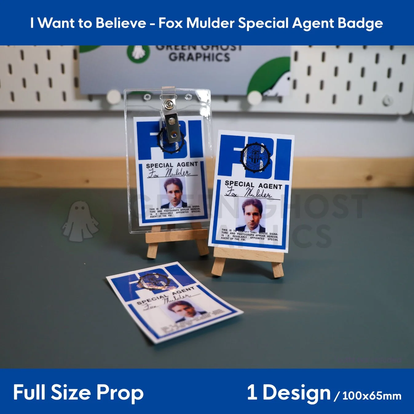 Three blue and white Fox Mulder FBI ID badges featuring the text “SPECIAL AGENT” arranged on small wooden easels and a flat surface.
