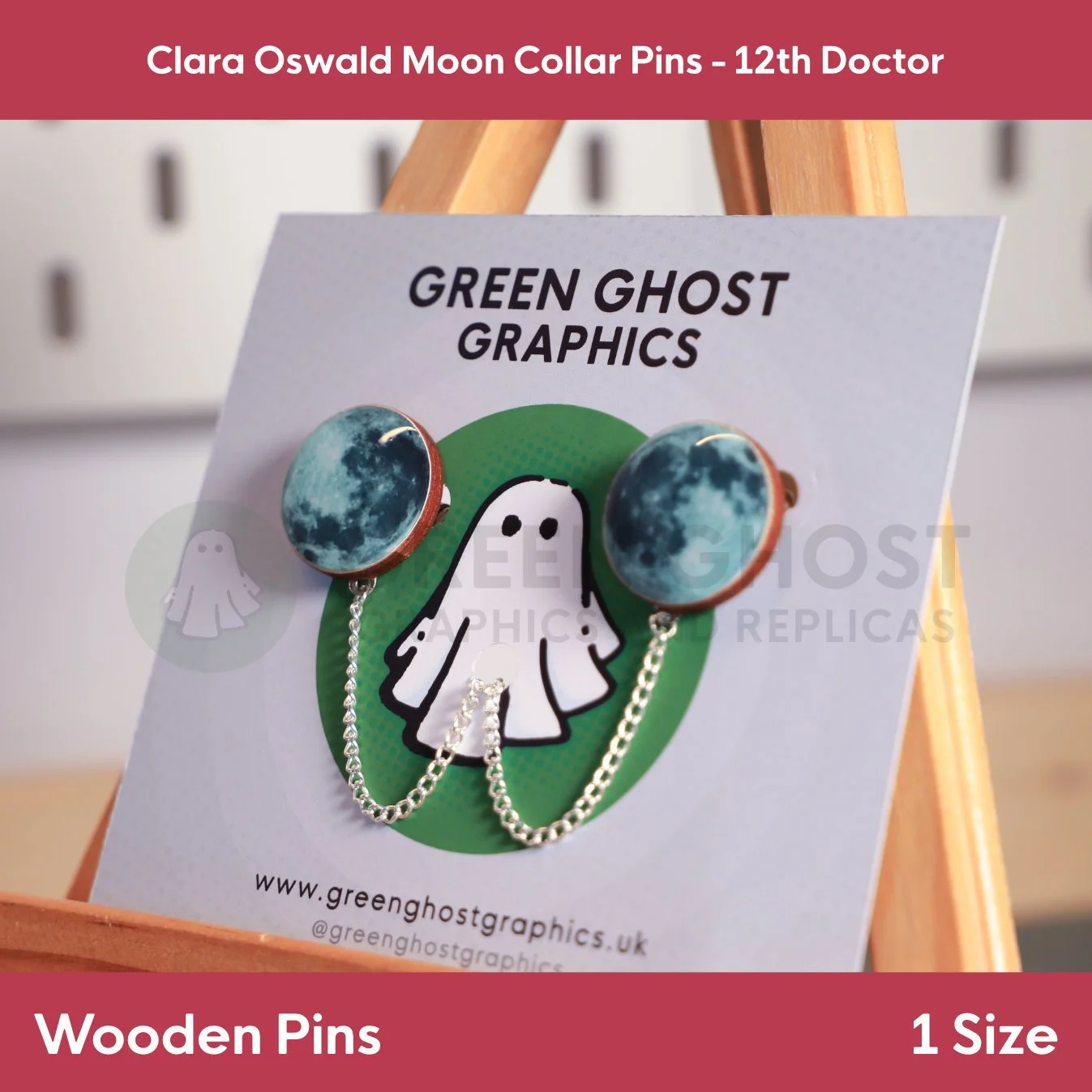 Circular moon‑print collar pins connected by a short chain and mounted on a green‑themed branded backing card.