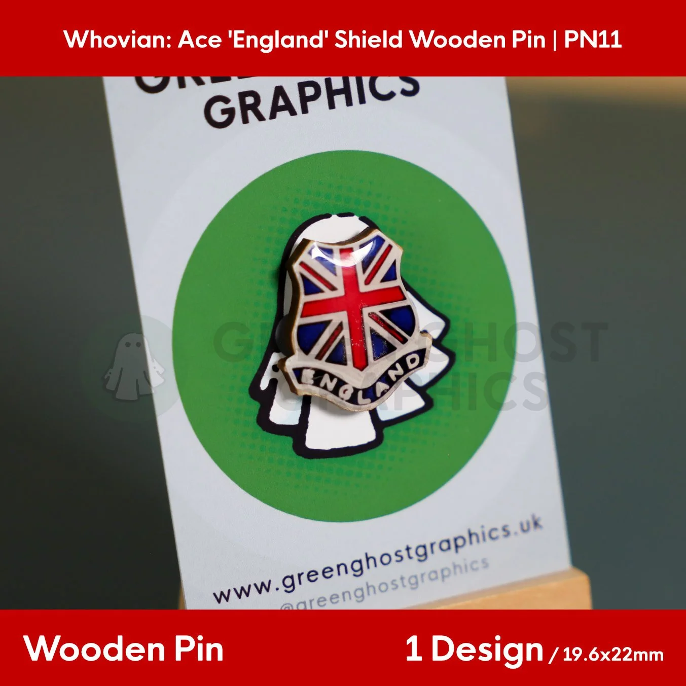 A shield‑shaped wooden pin with a red, white, and blue Union Jack design and the text “ENGLAND” mounted on a Green Ghost Graphics display card.