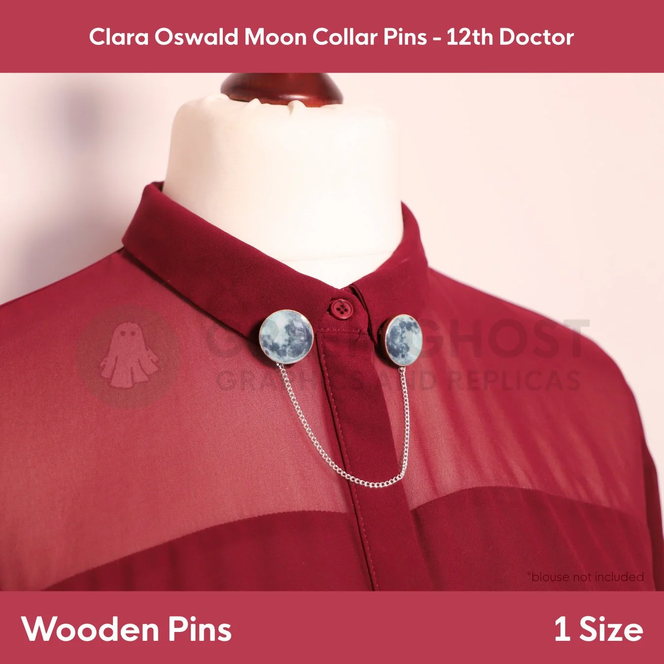 A pair of round moon‑print collar pins linked by a silver chain shown on a mannequin wearing a burgundy blouse.