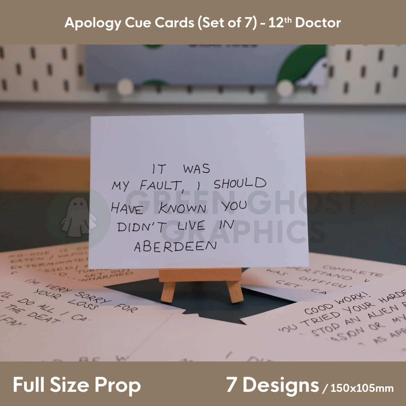 A white rectangular cue card reading “IT WAS MY FAULT, I SHOULD HAVE KNOWN YOU DIDN'T LIVE IN ABERDEEN” displayed on a small wooden easel surrounded by other cue cards.