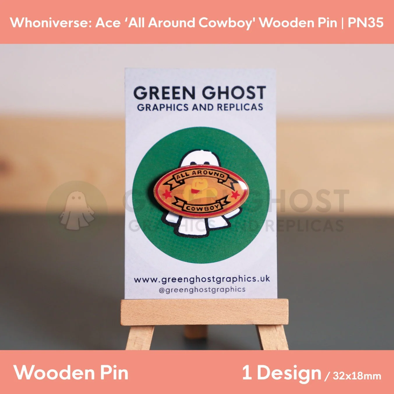 A close up shot of the sandy oval “ALL AROUND COWBOY” wooden pin with black text, red and yellow detail on a wooden easel.