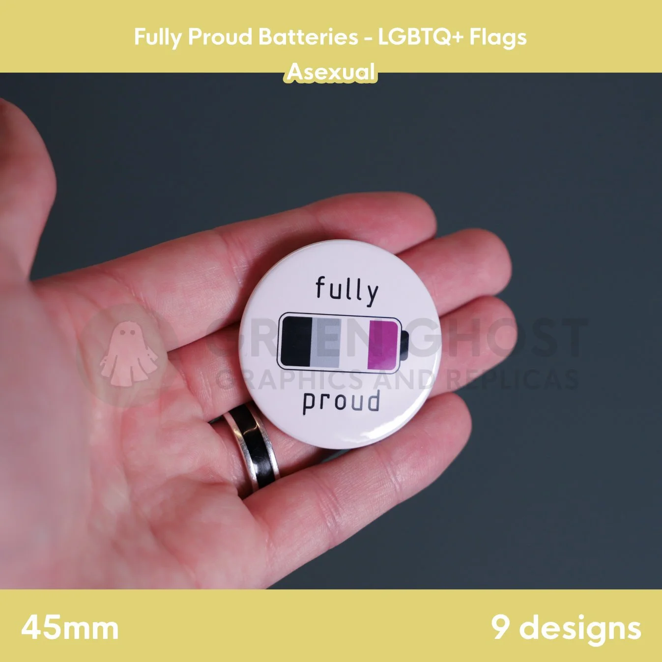 A round badge with an black, grey, white, and purple battery design held in a hand against a grey background.