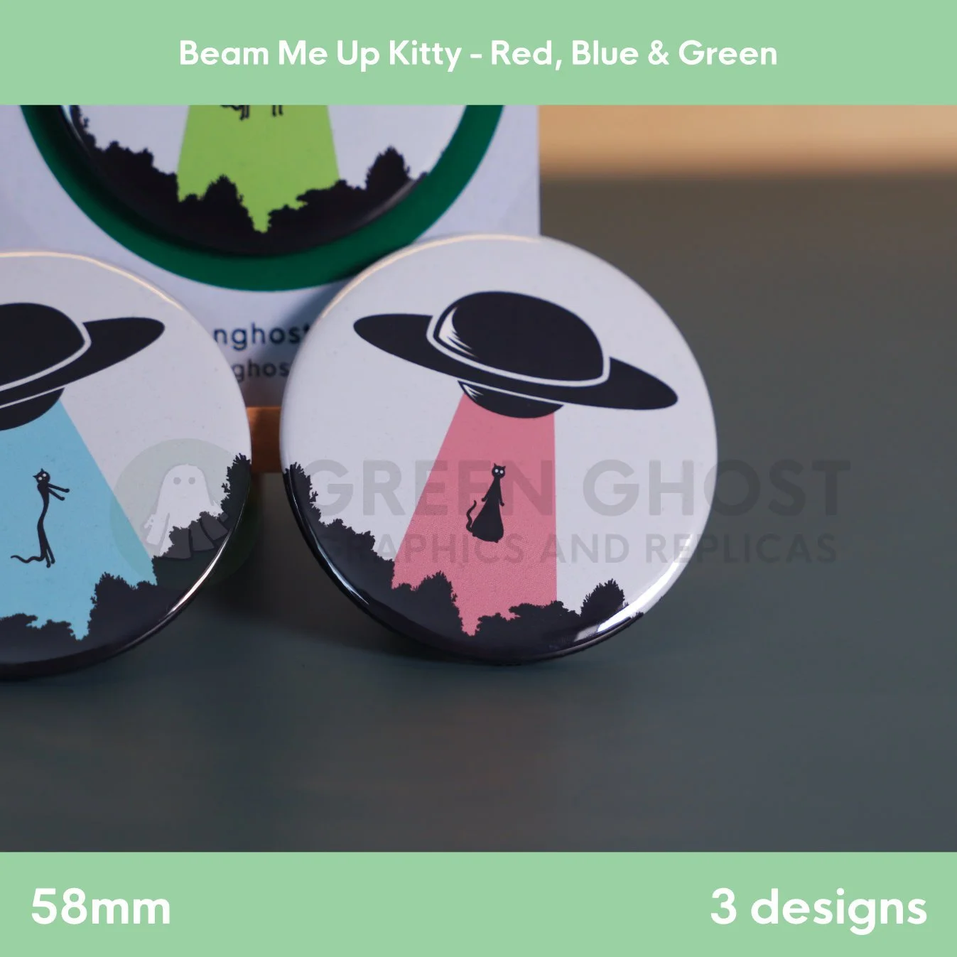 Three round badges with red, blue, and green UFO beams lifting a cat arranged side by side on a surface.