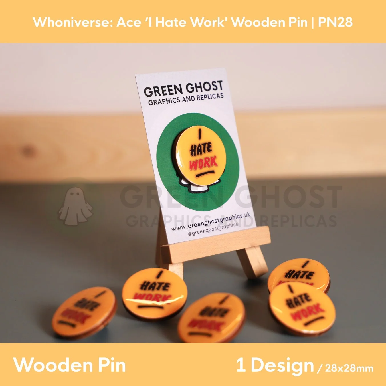A circular “I HATE WORK” wooden pin attached to a branded backing card on a wooden easel, with several identical pins scattered around the base.