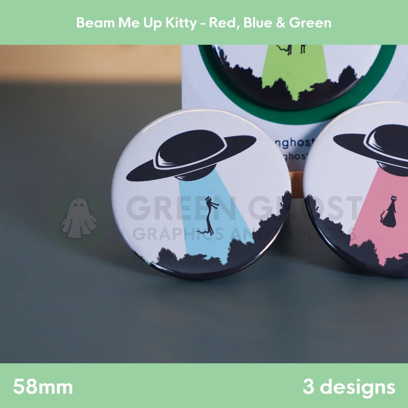 Three round badges with blue, green, and red UFO beams lifting a cat displayed together on a flat surface.
