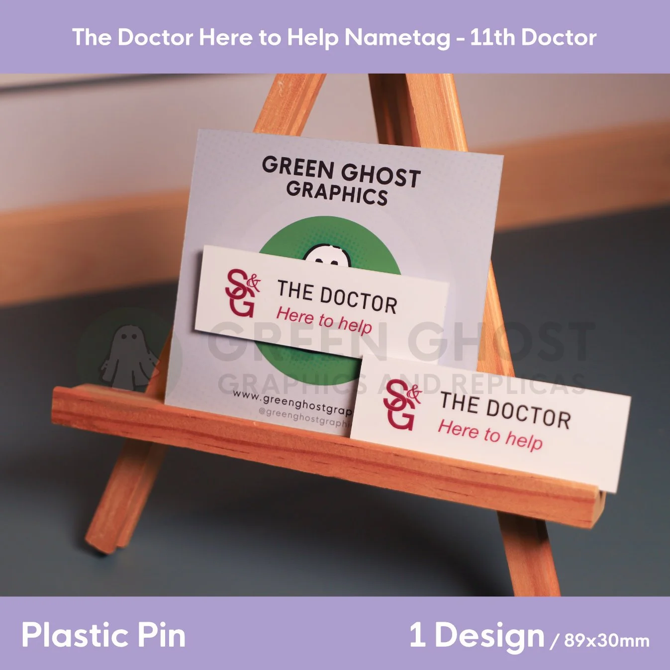 A rectangular white nametag with black and red lettering displayed on a wooden easel against a branded backing card.