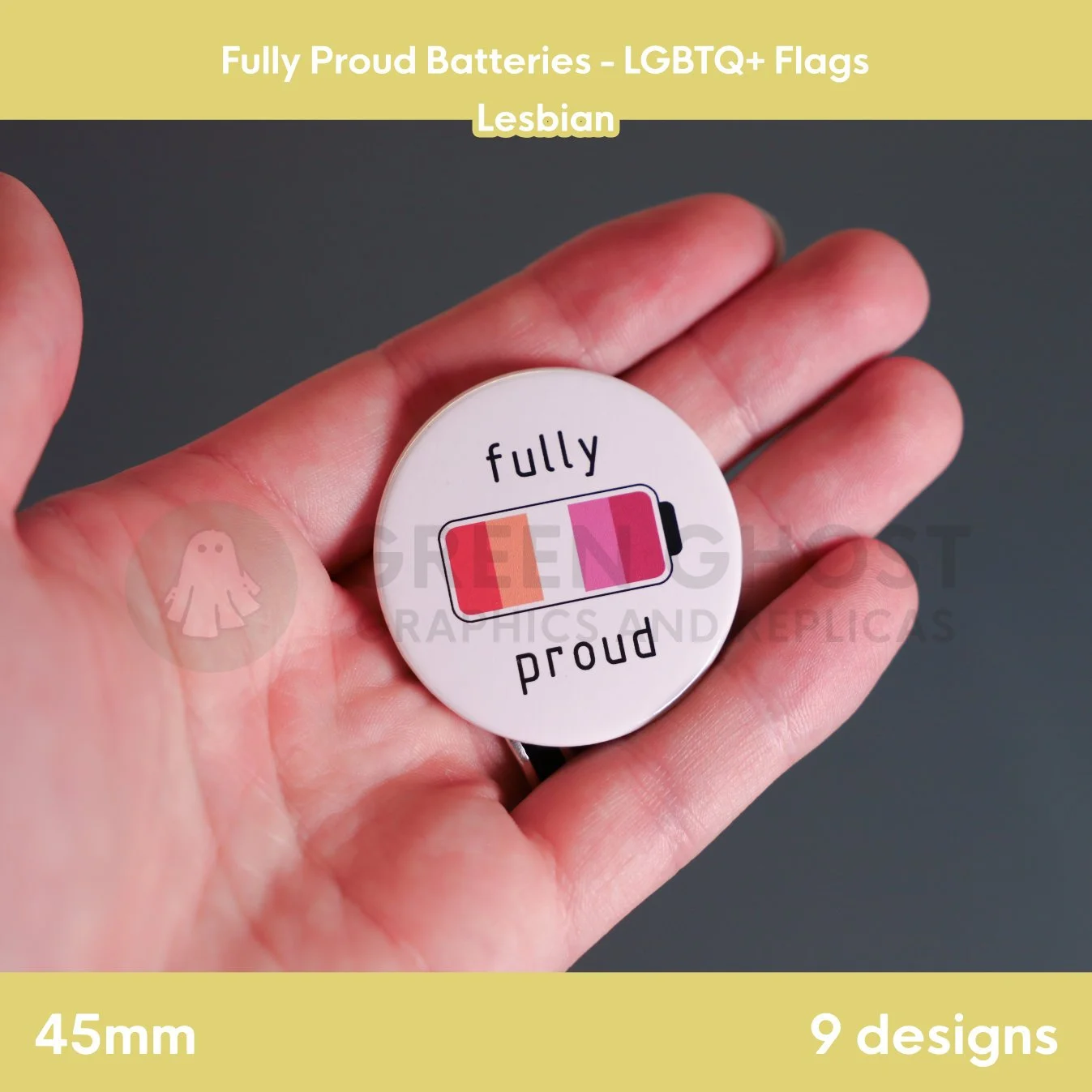 A round badge with an orange, white, pink, and red battery design held in a hand against a grey background.