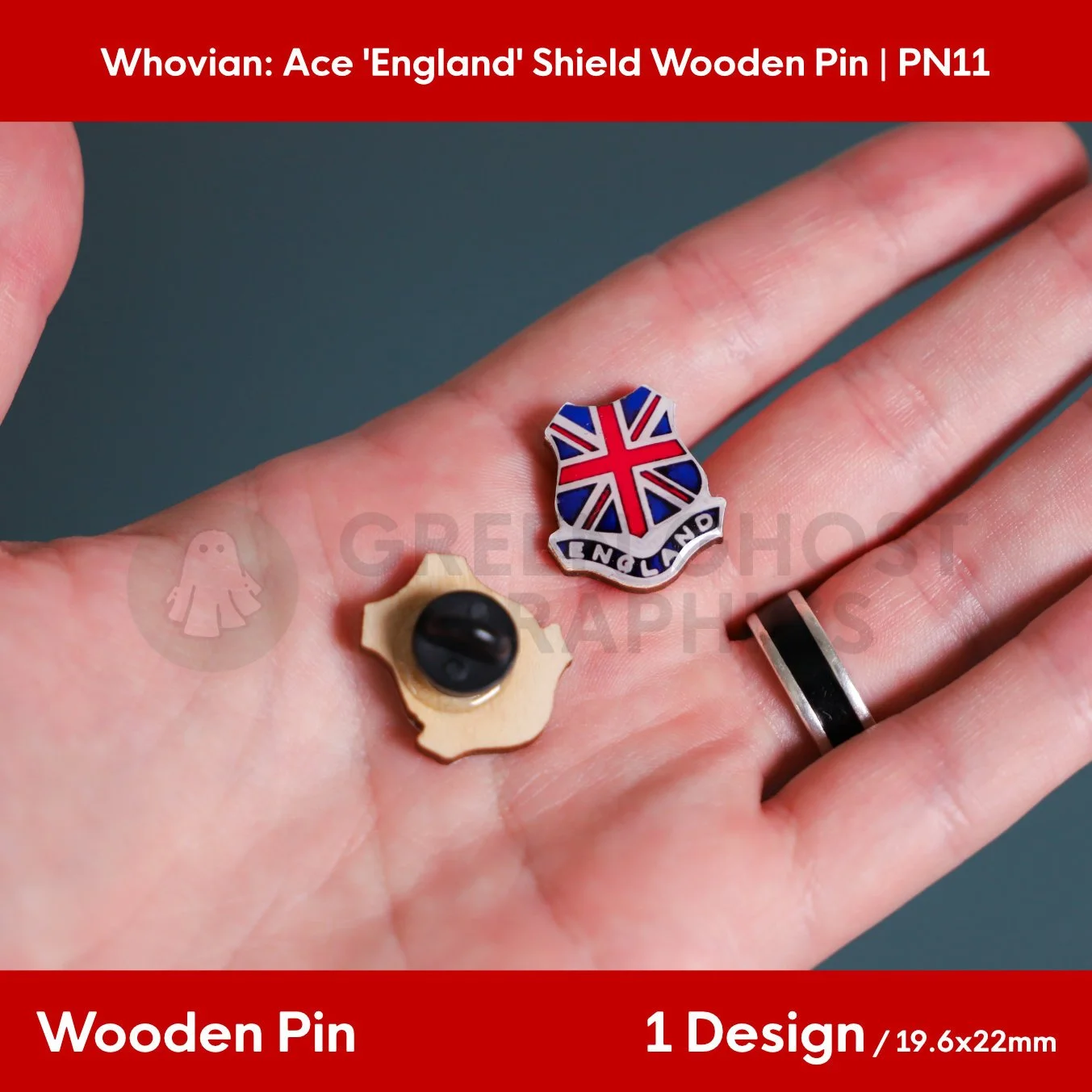 A hand holding the front and back of a shield‑shaped wooden pin featuring a Union Jack pattern, “ENGLAND” text, and a black rubber clasp.