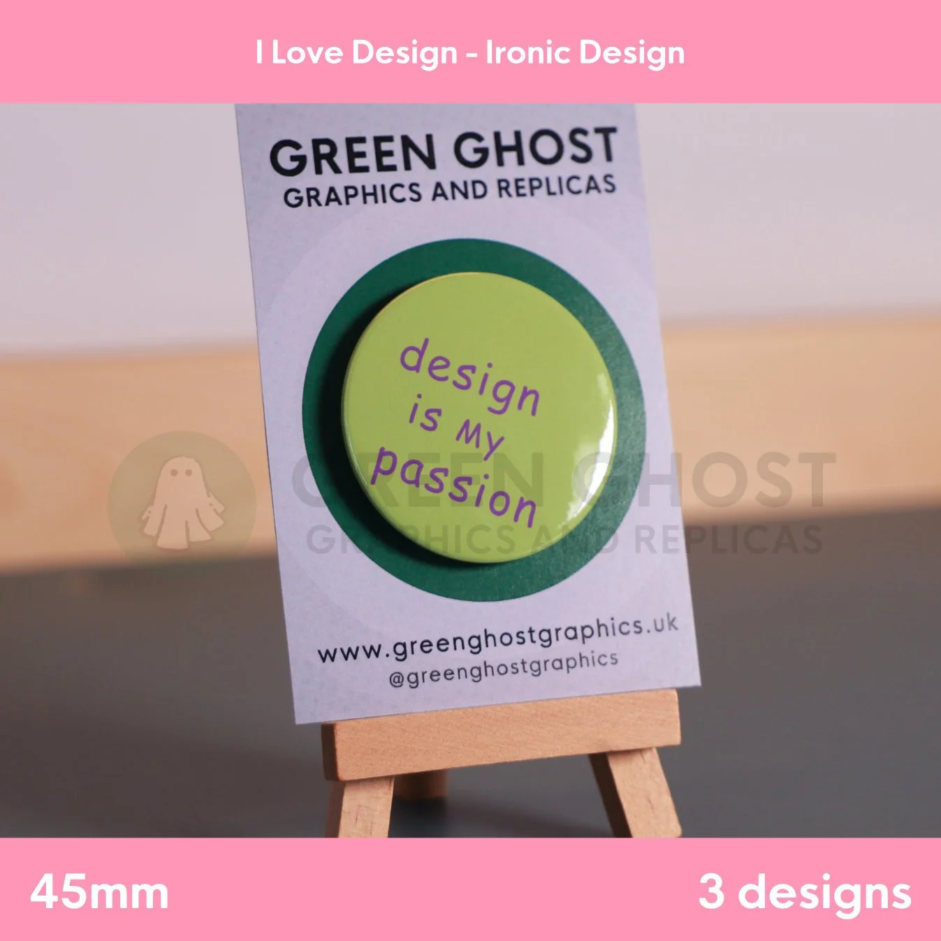 A circular green badge with purple “design is my passion” lettering mounted on a branded backing card on a wooden easel.