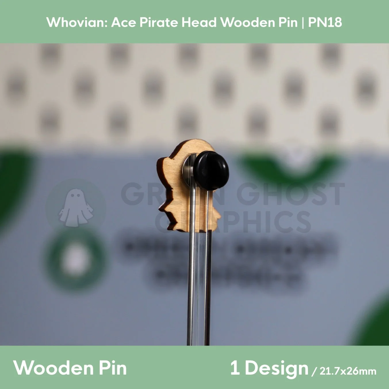 The back of a pirate‑head‑shaped wooden pin with a natural wood finish and black rubber clasp displayed on a clear stand.