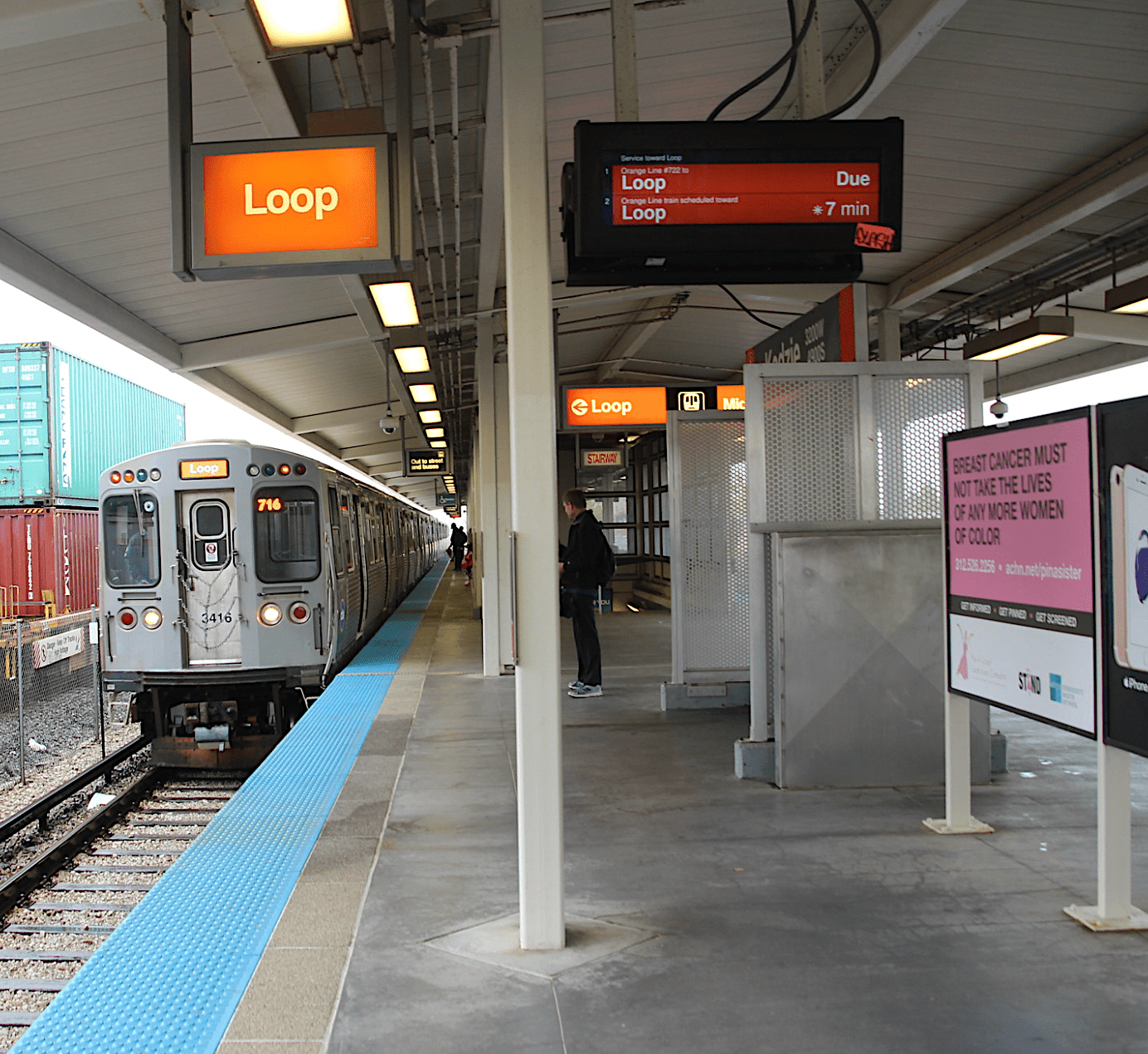 Orange Line train arriving at a Chicago L platform with a "Loop" destination sign overhead