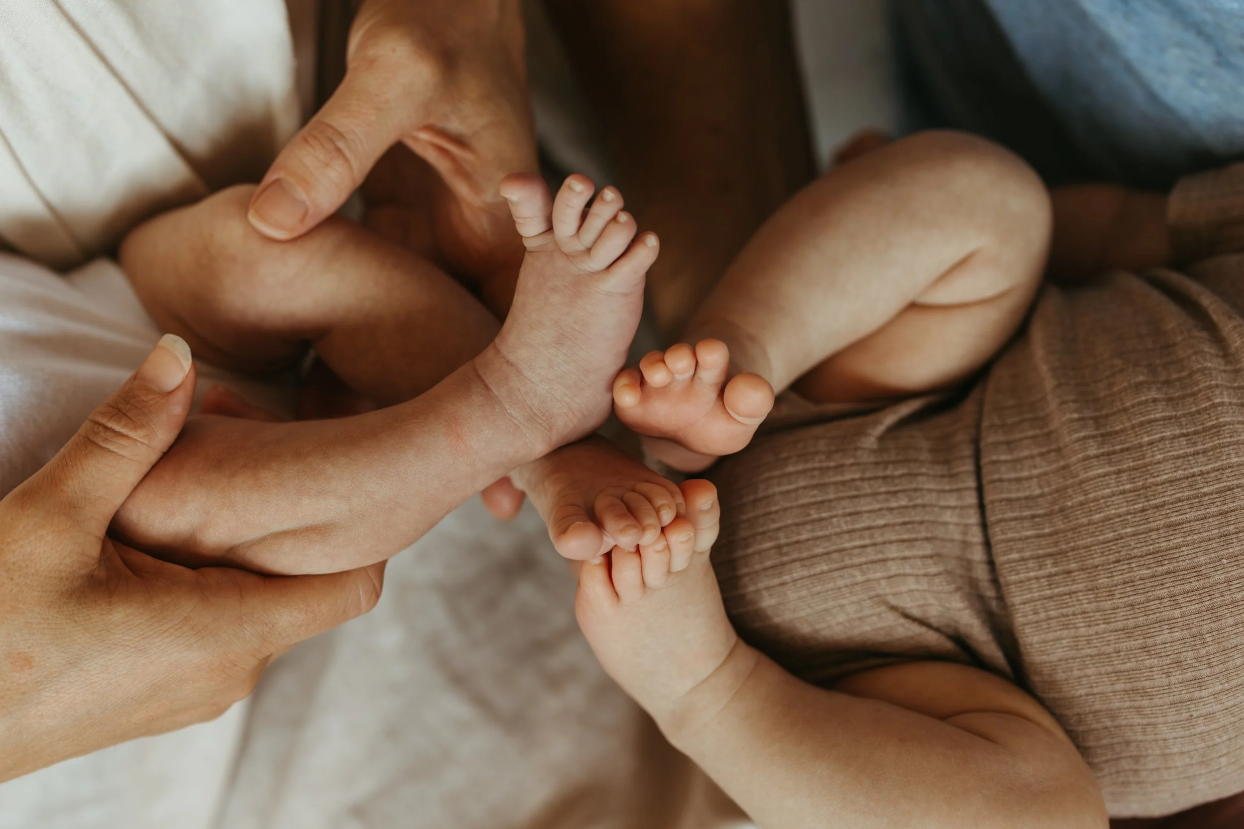 two twin baby foots being held by their parents for a fresh 48 session at home in melbourne 