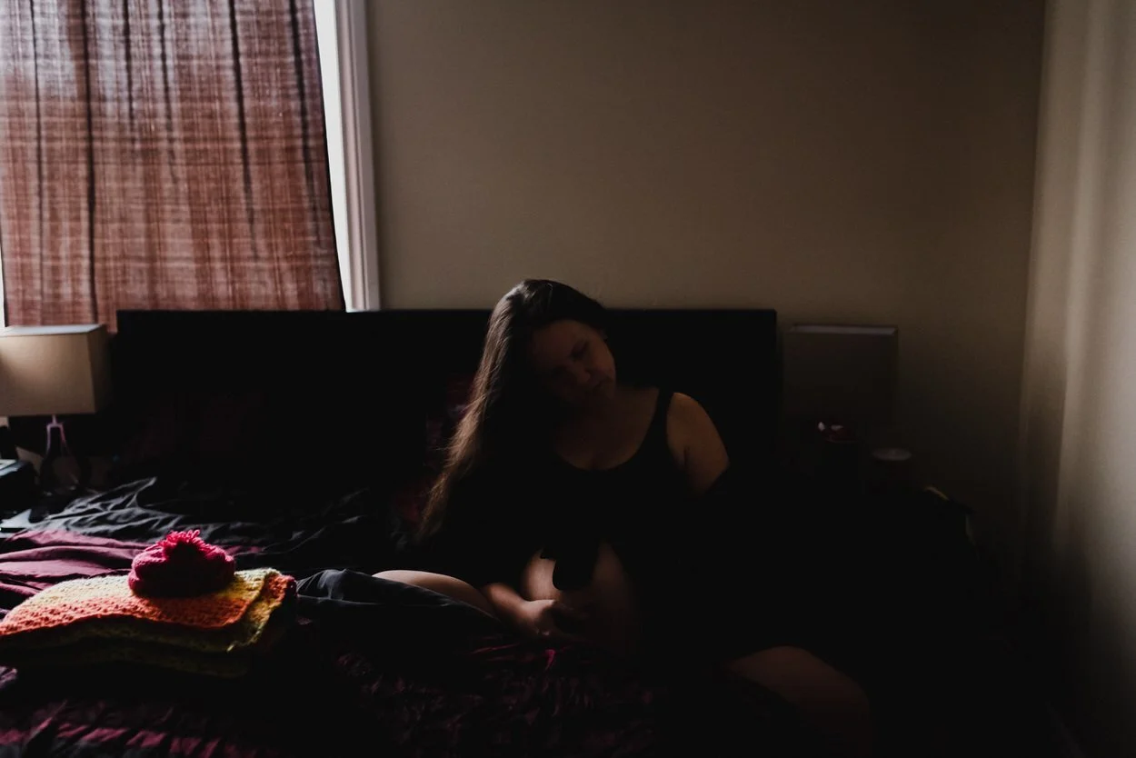 Woman in a slit of light in labour at her home in Ottawa, Ontario.