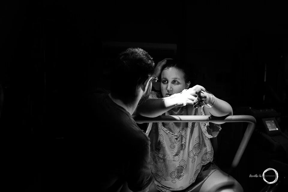 Mom and dad look at each other while mom is in labour with their baby. She is resting.