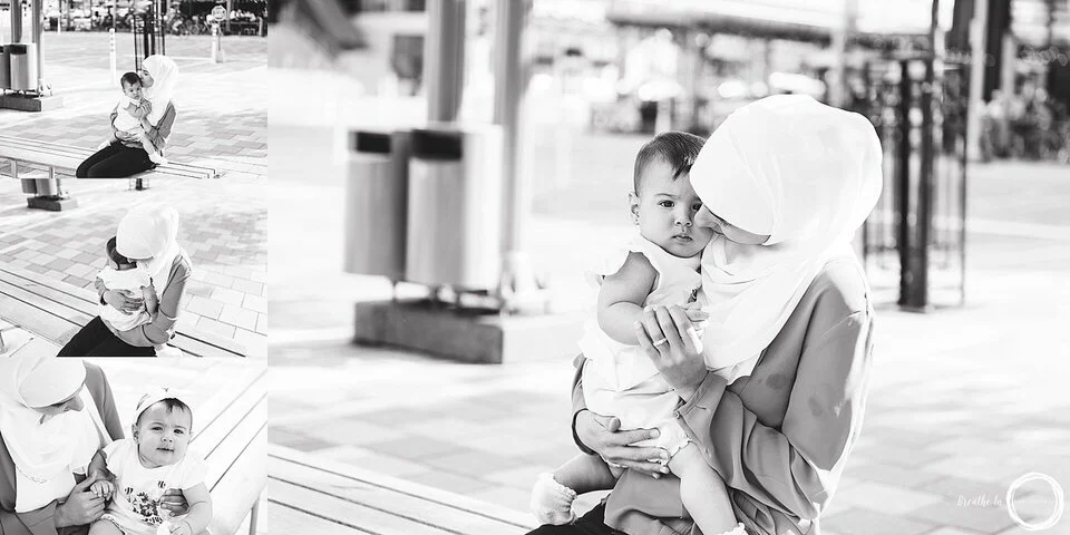 Mom and baby sitting on bench. Photos are in black and white and the focus in on the connection between the mom and baby.