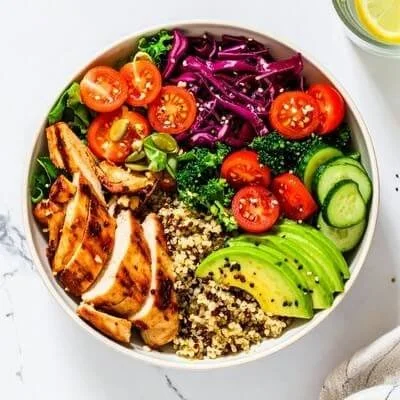 chicken avocado tomato cabbage salad in a white bowl