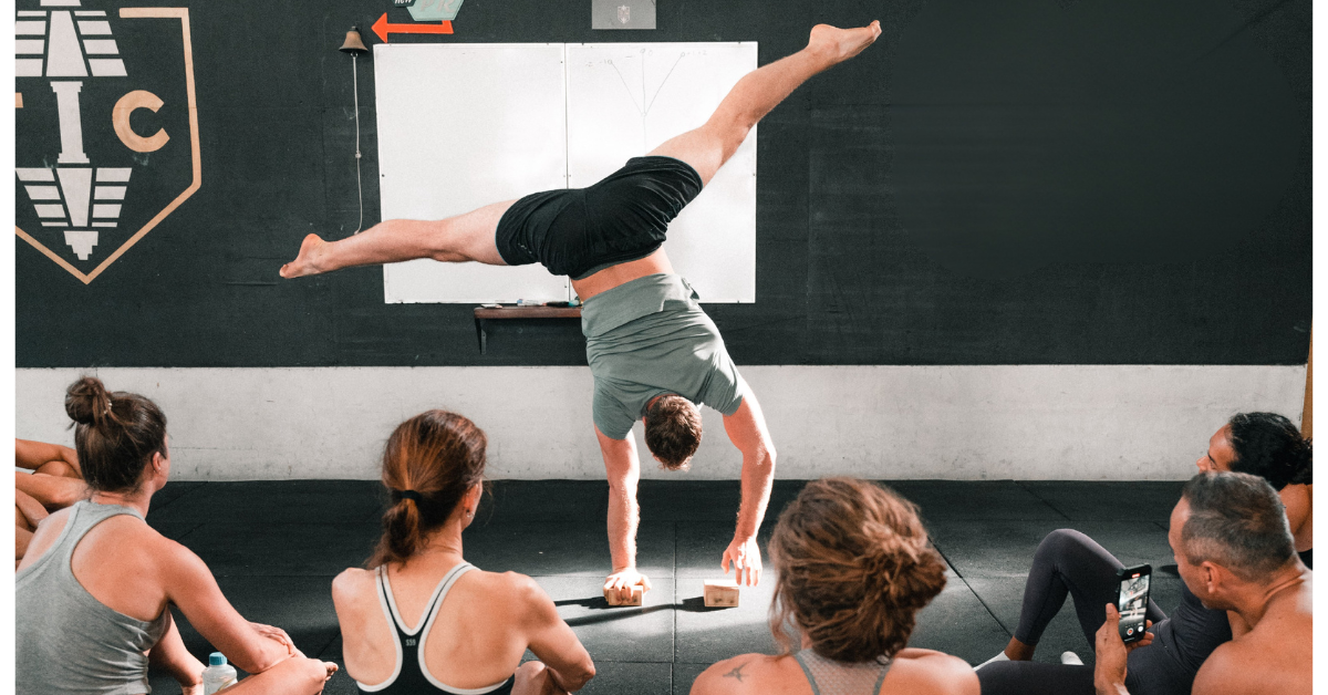 Man showing a handstand to a group of students