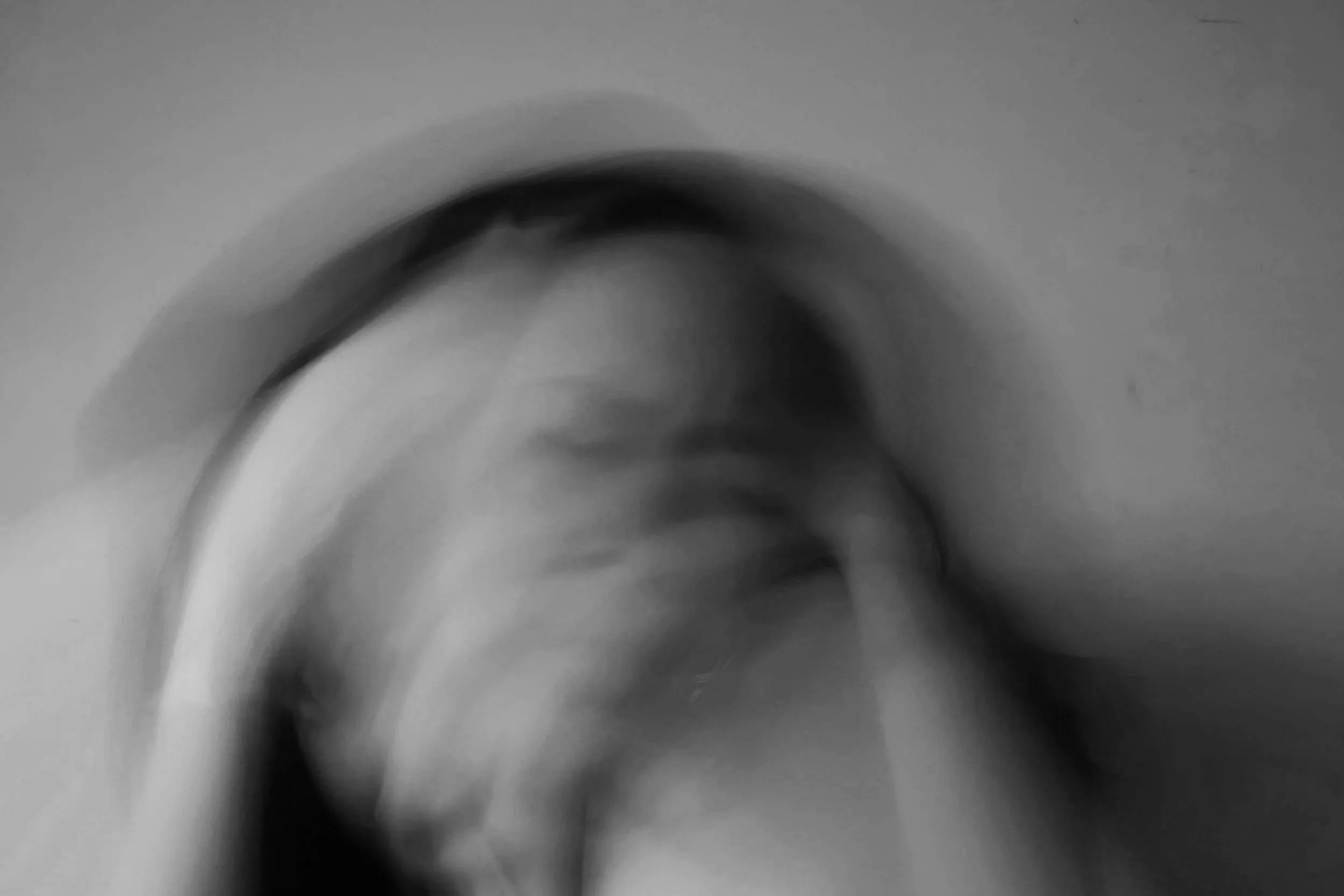 Blurred black & white photo of woman, creating feelings of unease. Overcoming Overthinking Tips.