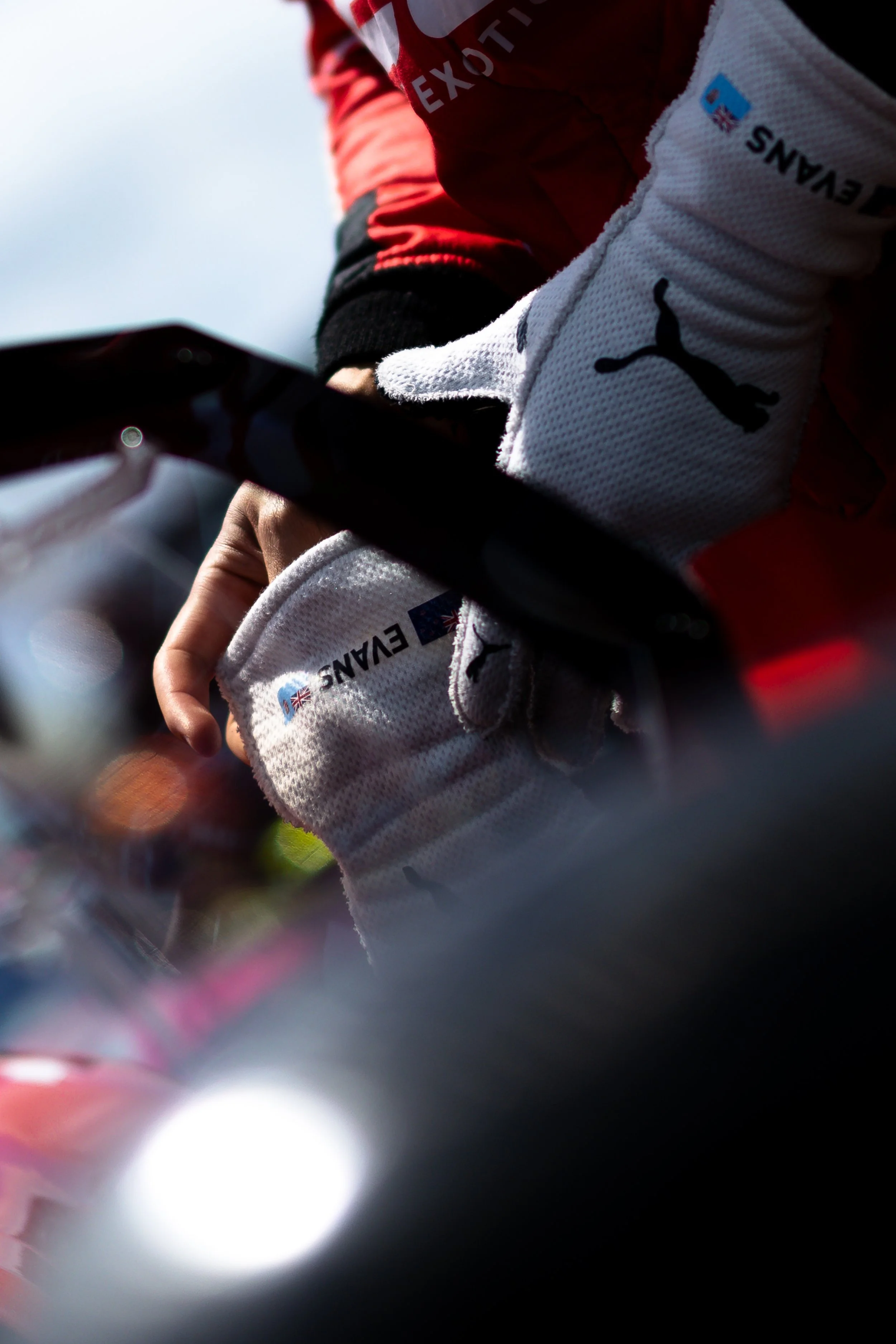 Jaxon Evans putting gloves on before entering the Arise Racing GT Ferrari 296 race car. 