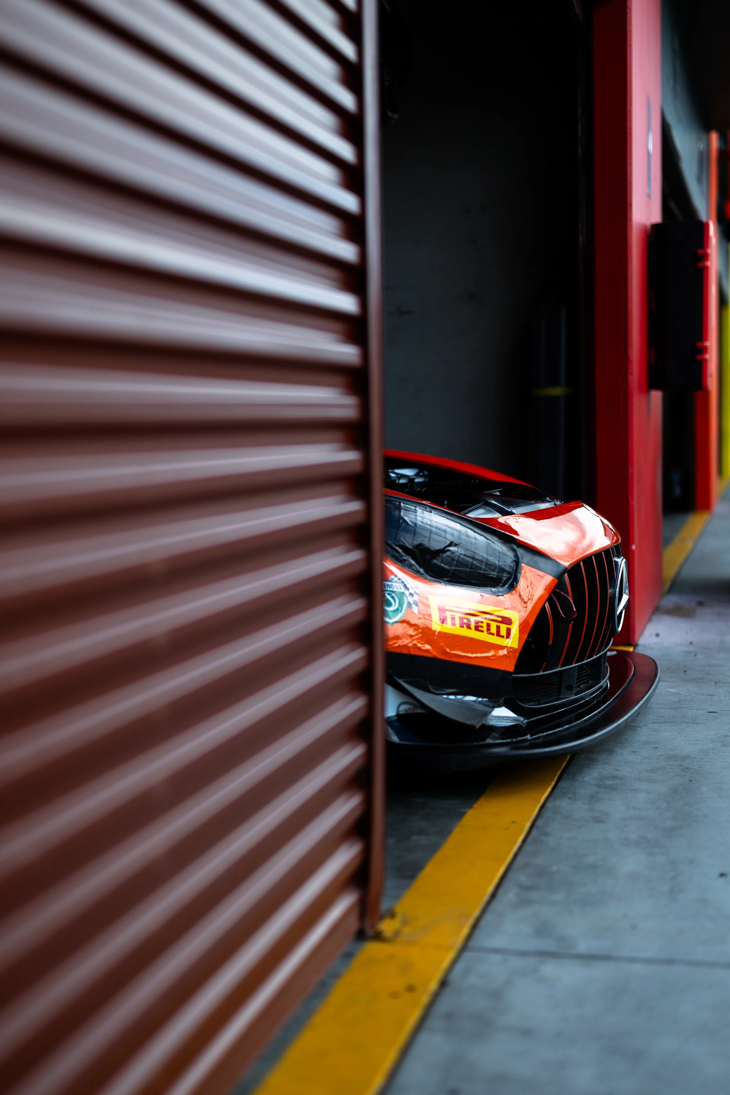 Blackwolf Racings Mercedes AMG GT3 race car poking its nose out of the garage.