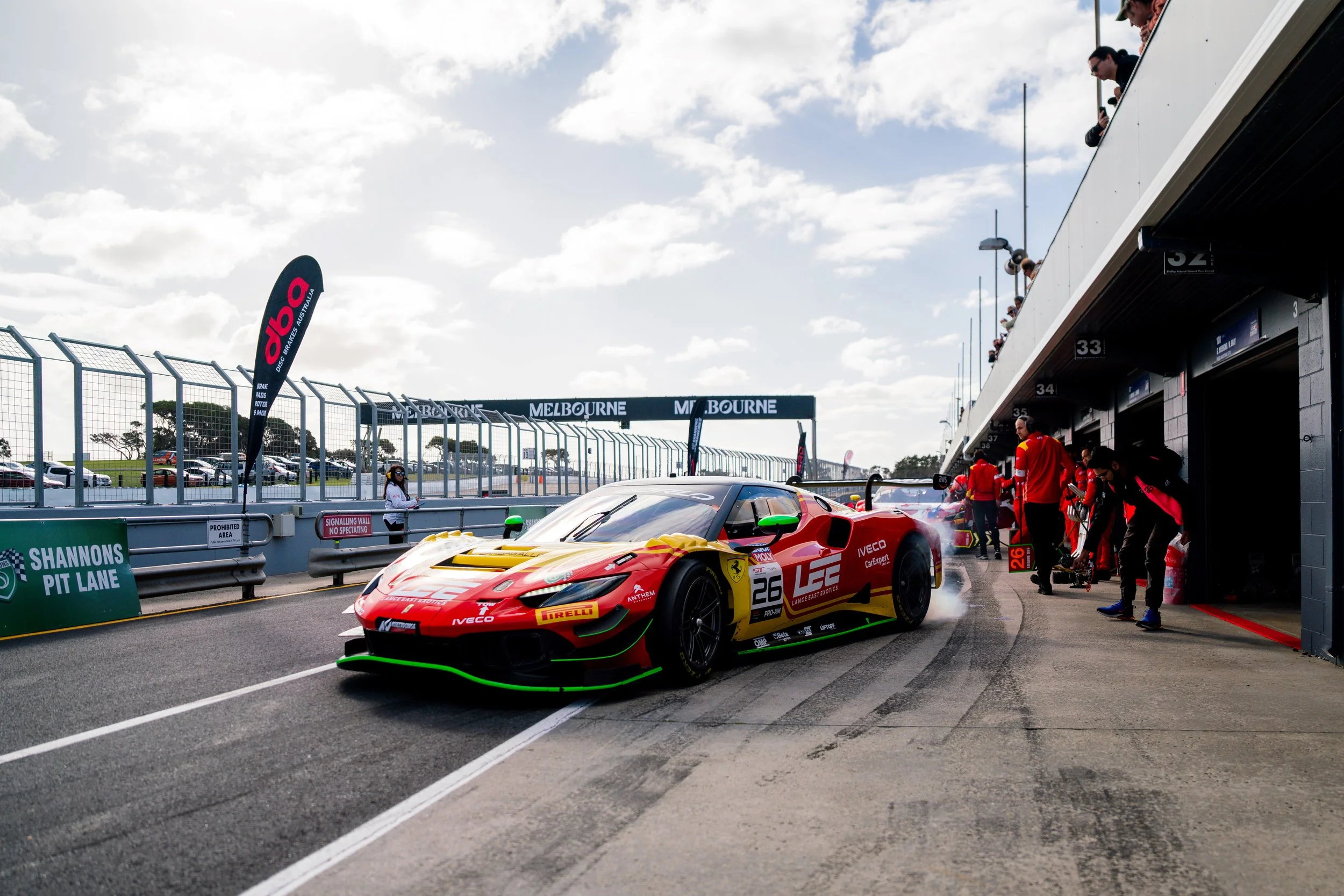 Arise Racing GT performing a burnout as it leaves the pit box with crew behind at Phillip Island during the 2025 GT World Challenge Australia round.