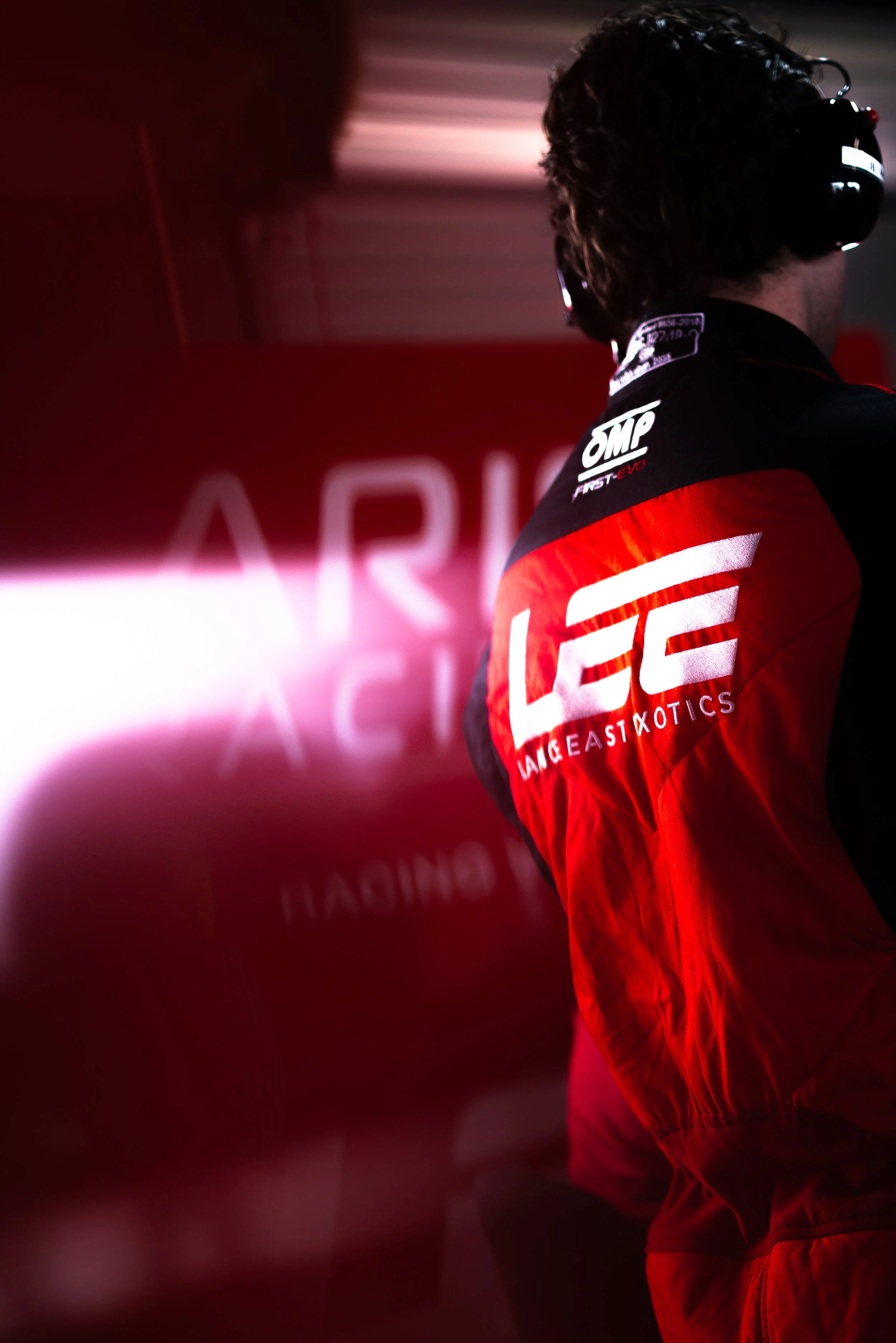 Arise Racing GT pitcrew wih a sun flare on the team branding. 