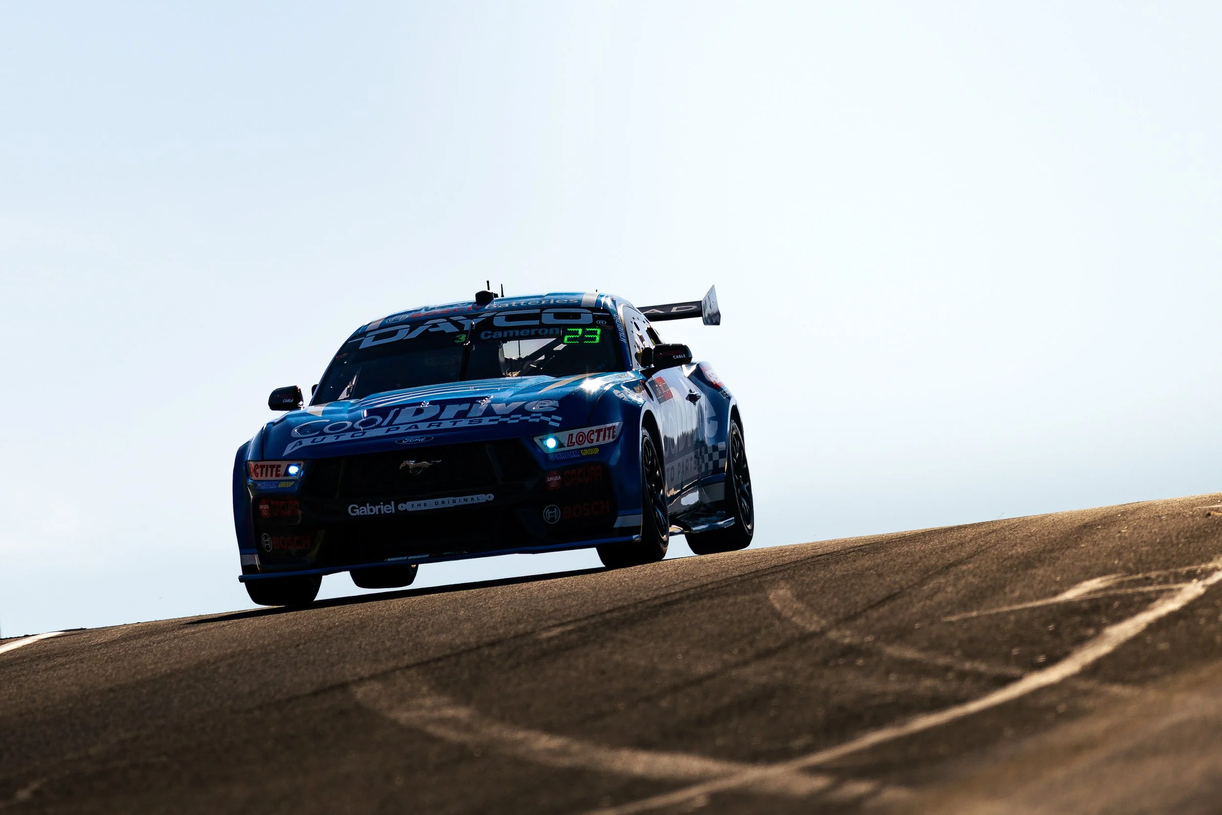 Blanchard Racings Supercars Ford Mustang passing over Skyline at the 2025 Bathurst 1000 during sunset.