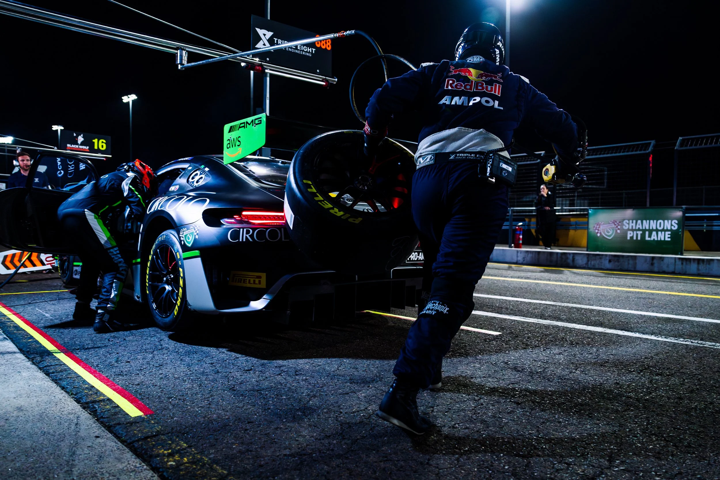 Night pit stop of Triple Eight Race Engineering’s crew running with a tyre as Declan Fraser and Peter Hackett perform a driver change at the 2024 GT World Challenge Australia round at Sydney Motorsport Park.