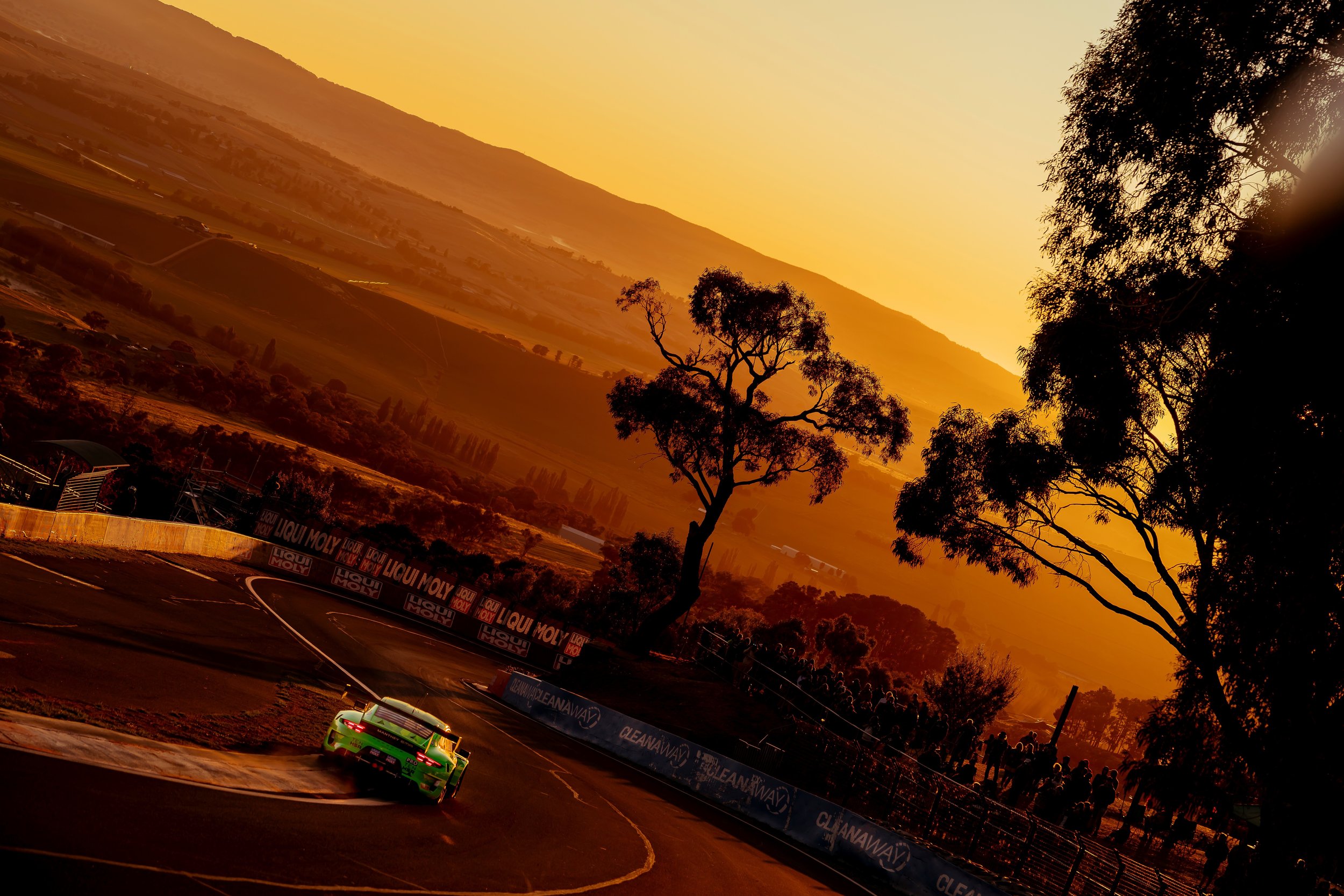 Manthey Racings 'Grello' through the esses during an orange sunrise at the 2023 Bathurst 12 Hour.