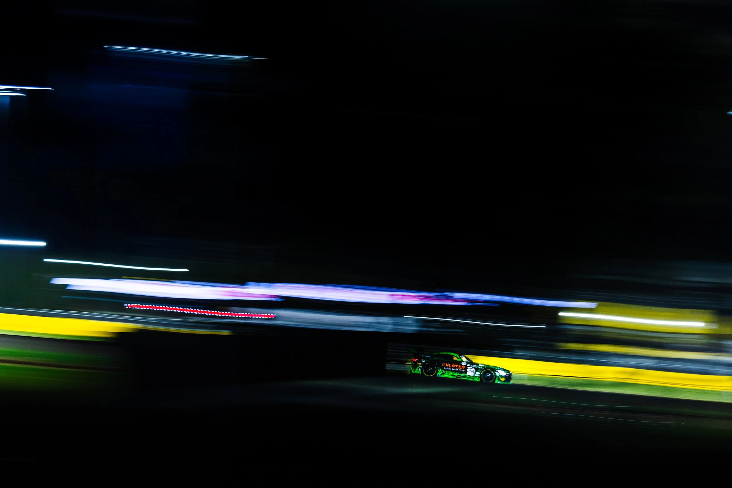 Garth Walden Racings Mercedes AMG Gt3 race car captured by a slow shutters speed during a night race at the 2024 Sydney Motorsport Park round of the GT World Challenge Australia.