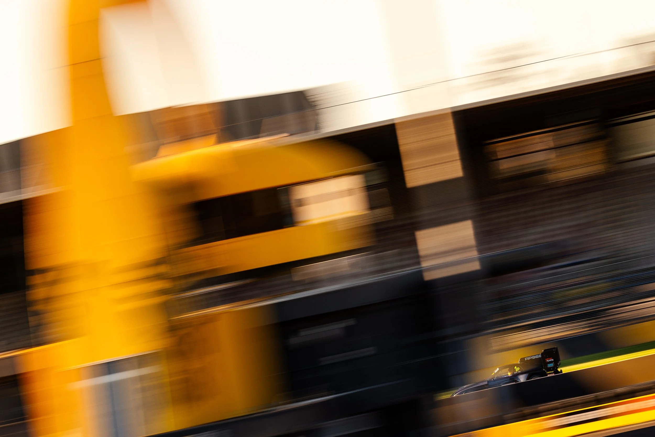 P968 race car captured in a slow pan shot passing the control tower at Sydney Motorsport Park during the 2024 World Time Attack Challenge