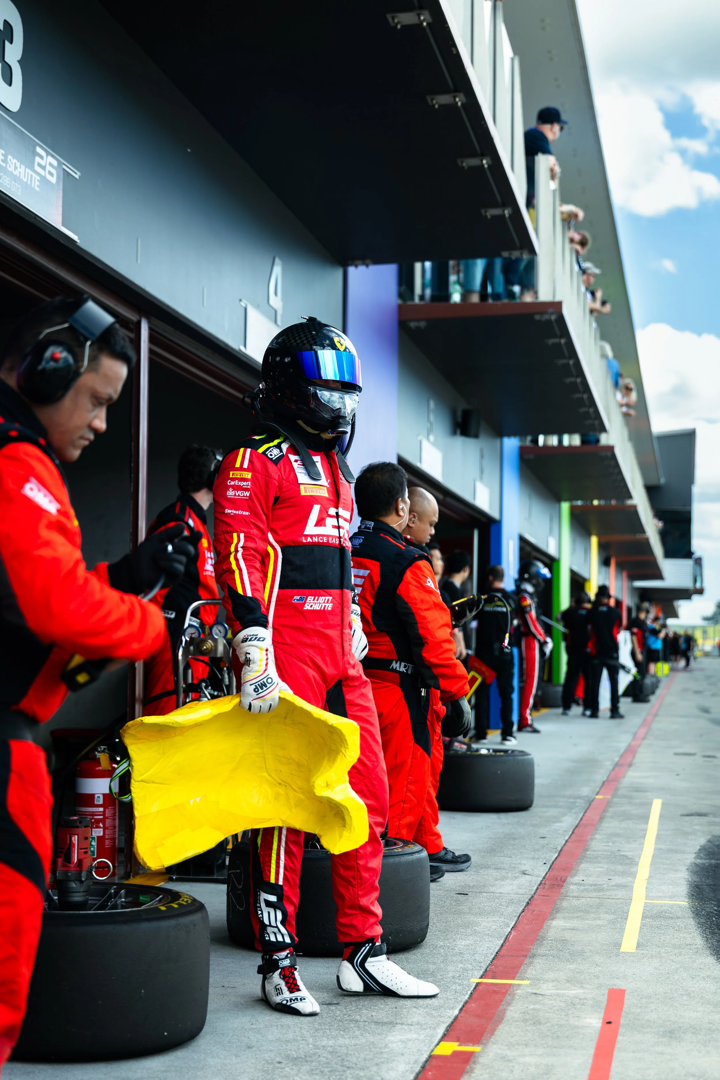 Elliot Shutte waiting for the Arise Racing GT Ferrari 296 GT3 race car to enter the pit box at the 2025 Hampton Downs GT World Challenge Australia race event.