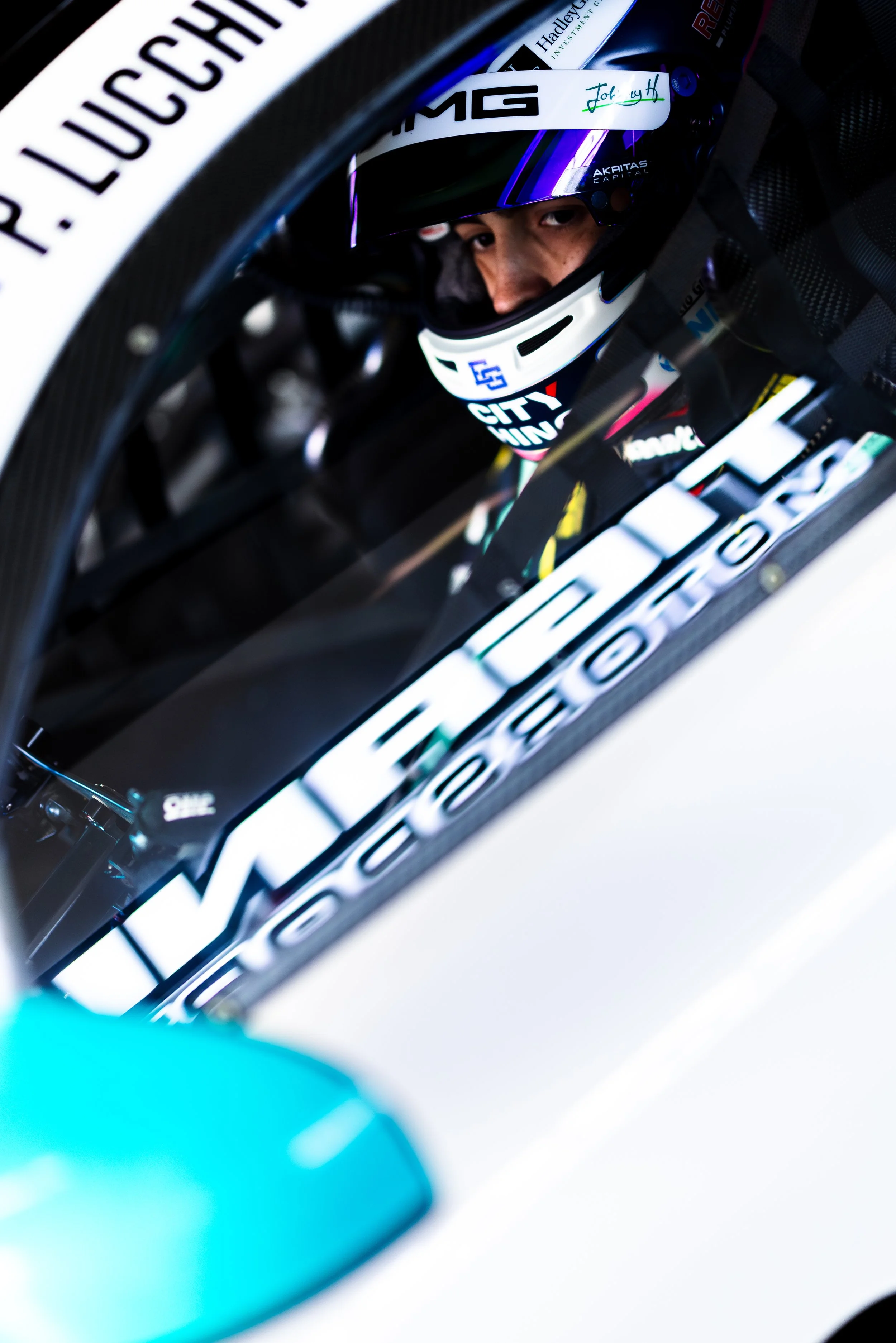 Jayden Ojeda aboard the Tigani Motorsport Mercedes AMG GT3 with the teams pit board reflecting on the window.
