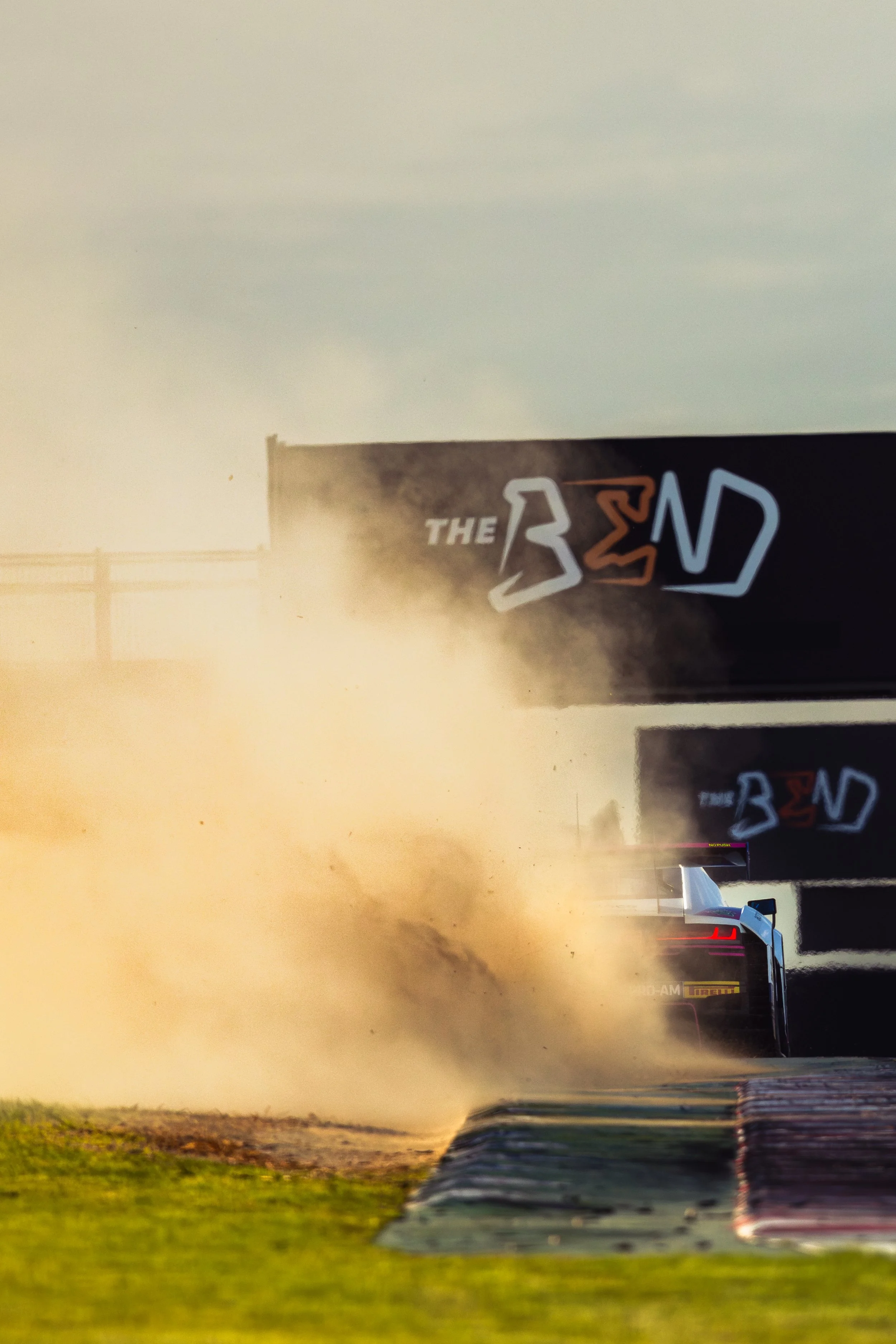 BRM Audi R8 LMS GT3 driven by Alex Peroni and Mark Rosser goes wide and throws up dirt and rocks as it exits the final turn at the 2025 GT World Challenge Australia round at The Bend.