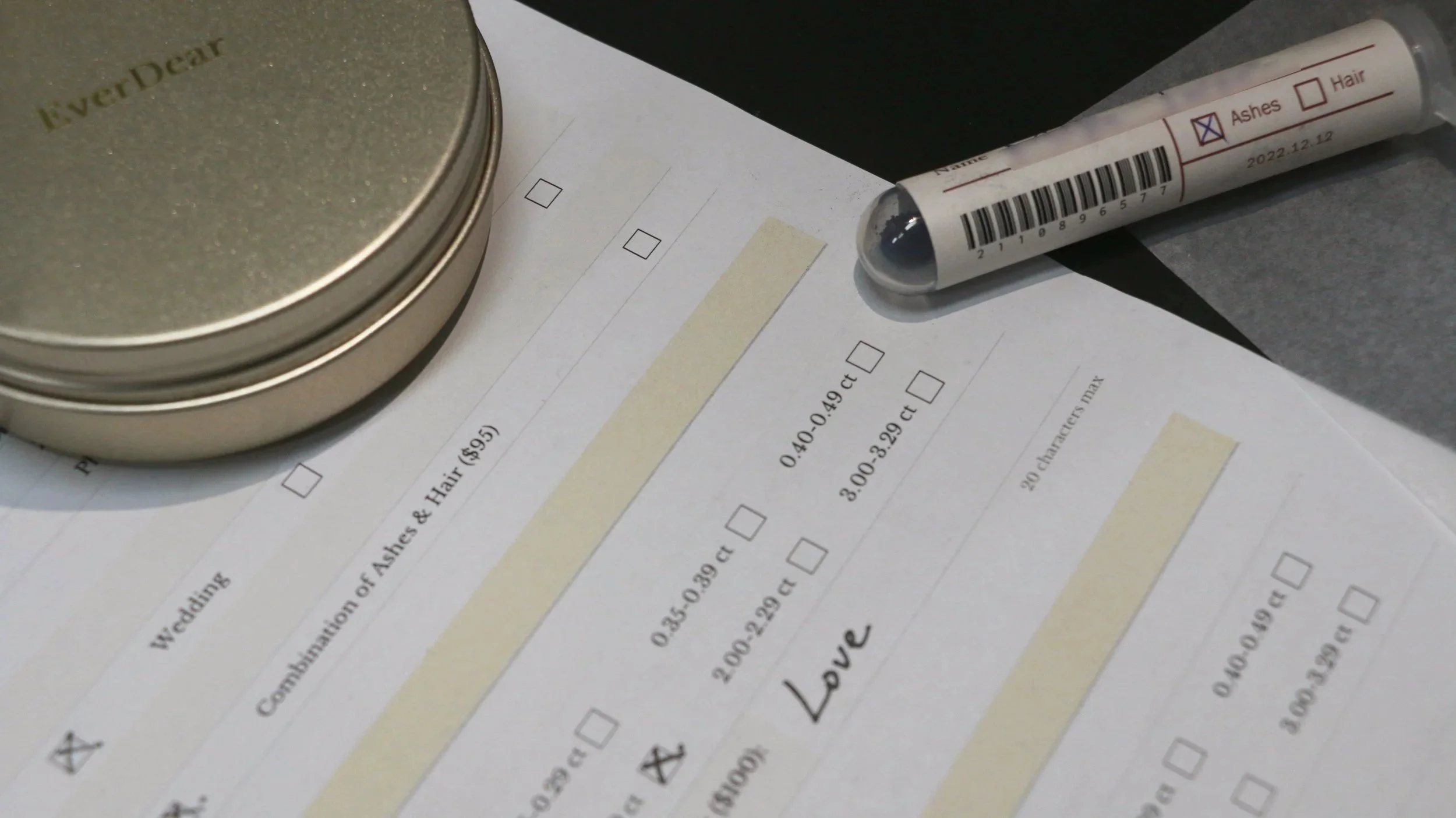 Formulaire de commande EverDear, tube d’échantillon étiqueté portant un code-barres et boîte souvenir associés à une commande de diamant commémoratif.