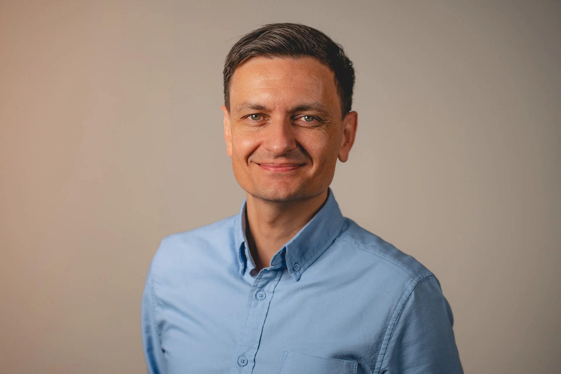 En smilende mann ser inn i kamera.