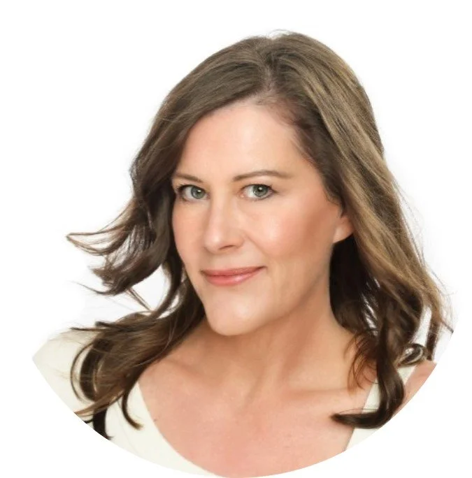 Close-up portrait of a woman with shoulder-length brown hair, wearing light makeup and a white top, smiling softly against a white background.