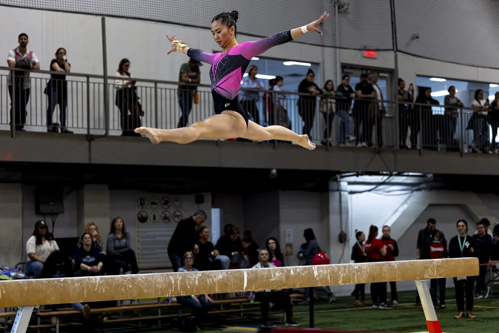 Gymnaste effectuant un saut à la poutre lors du Championnat québécois de gymnastique en 2026